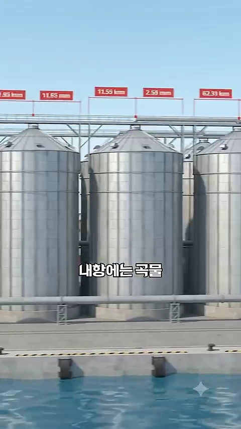 인천항 내항에 나란히 서 있는 대형 원통형 금속 곡물 사일로들과 상단에 수치 정보가 표시된 그래픽 화면