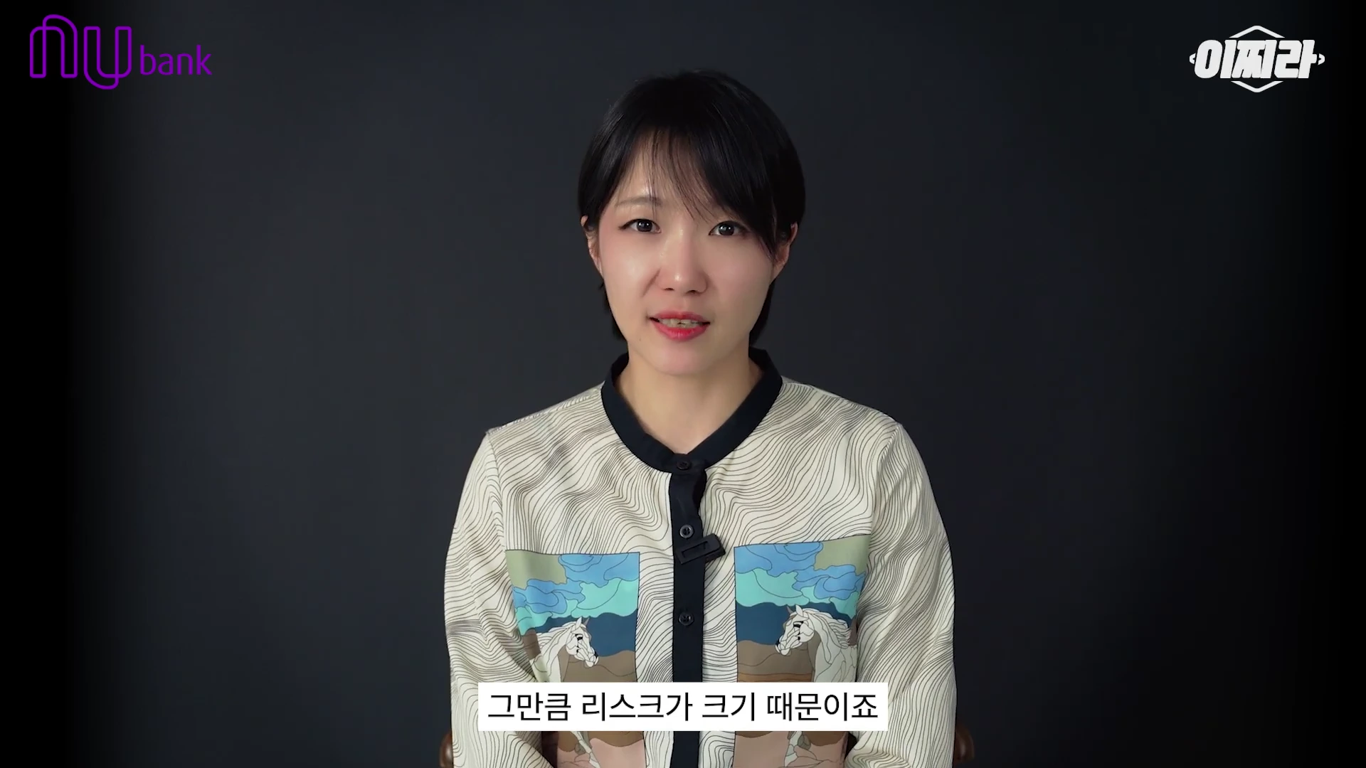 단발머리를 한 여성이 검은색 배경 앞에서 정면을 바라보며 이야기하고 있고 화면 아래에는 자막이 달려 있다.