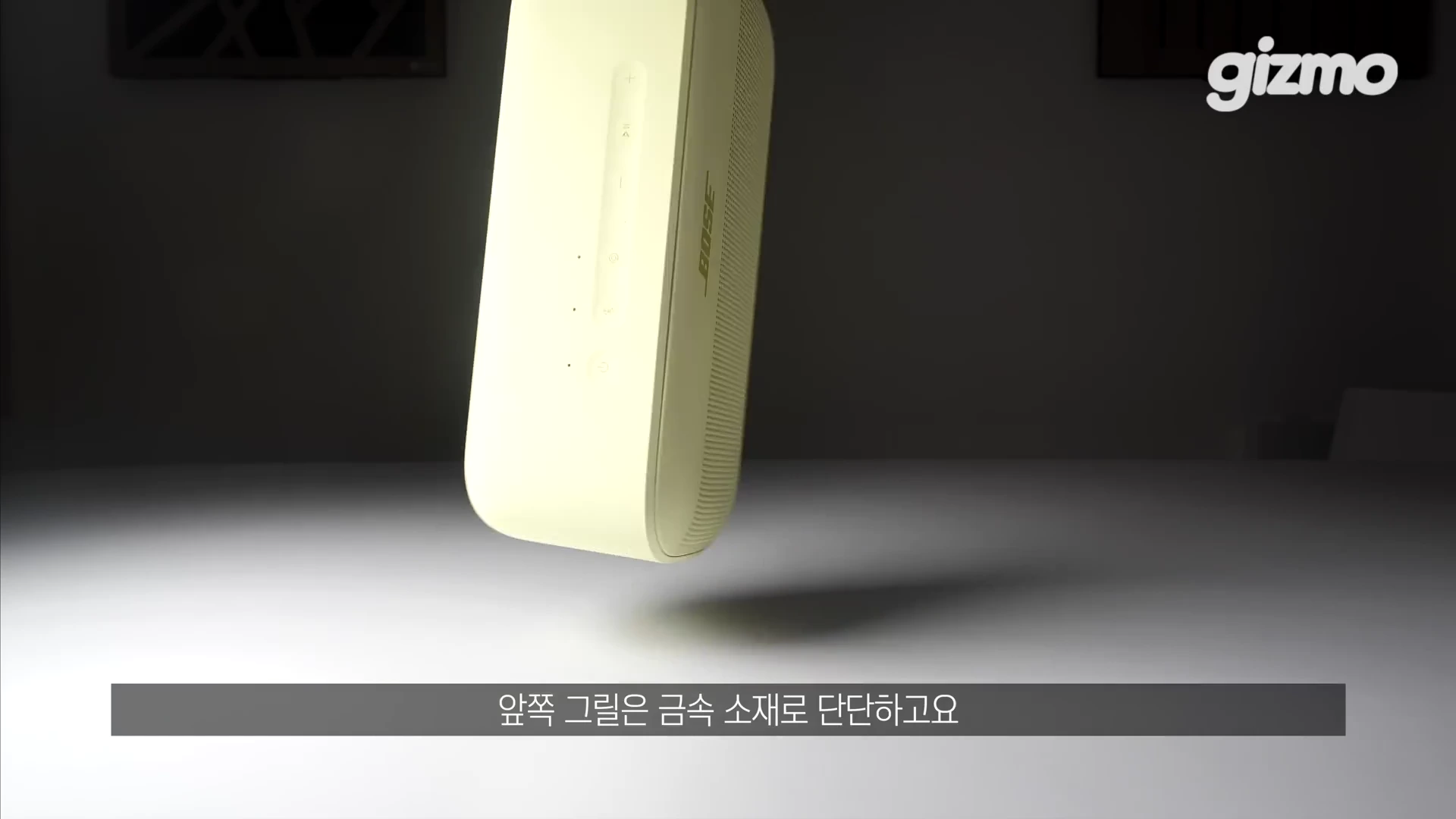 밝은 노란색의 사운드링크 플러스 휴대용 스피커가 테이블 위에 떠 있는 듯한 모습으로 정면을 향해 배치되어 있고 스피커 상단에 조작 버튼이 보인다.