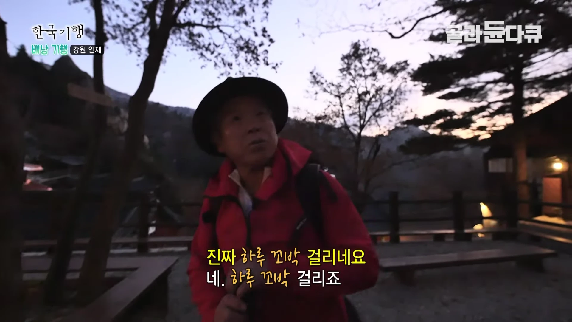 등산복 차림의 한 남성이 해질녘 야외에서 대화를 나누고 있는 모습이 담긴 방송 화면으로, 화면 하단에는 자막이 떠 있습니다.