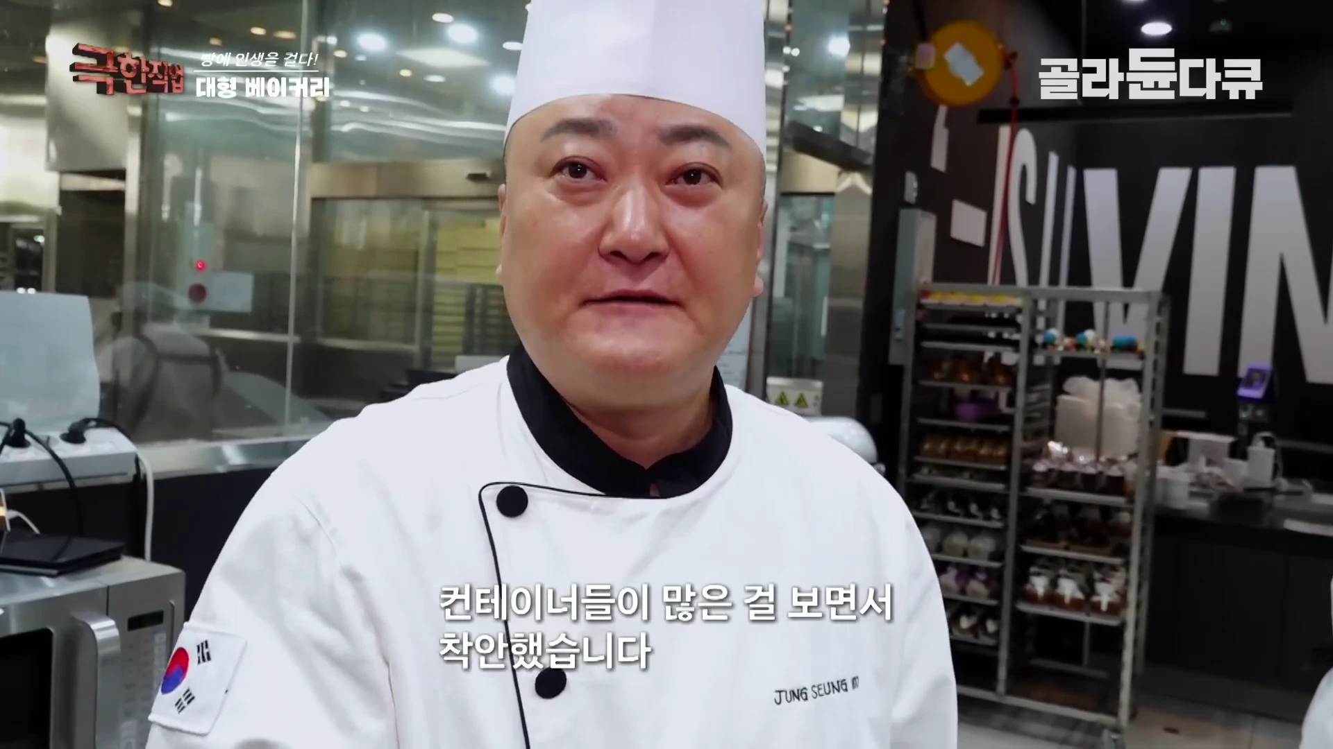 흰색 셰프 복장을 입은 남성이 주방을 배경으로 인터뷰를 하고 있다.