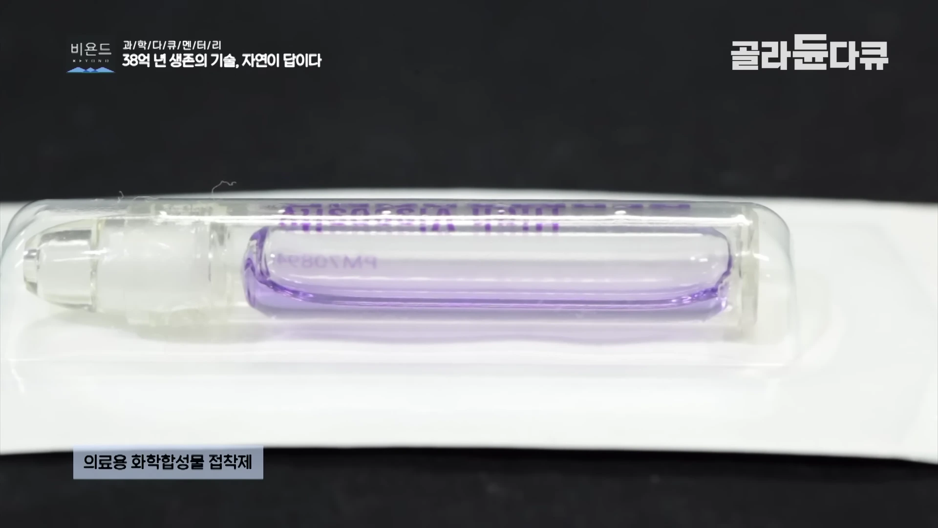 투명한 플라스틱 포장재 안에 보라색 액체가 들어 있는 의료용 화학 합성 접착제 샘플이 놓여 있다.