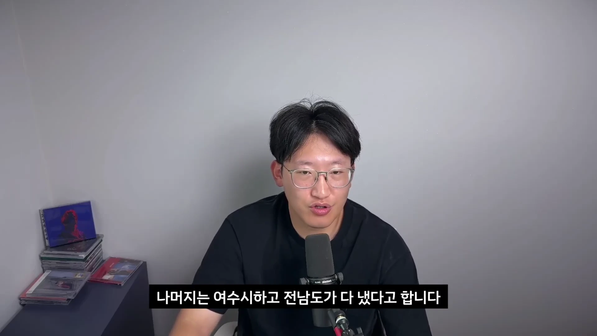 안경을 쓴 남성이 마이크 앞에서 이야기하고 있으며 하단에 한글 자막이 표시된 유튜브 영상 캡처 화면