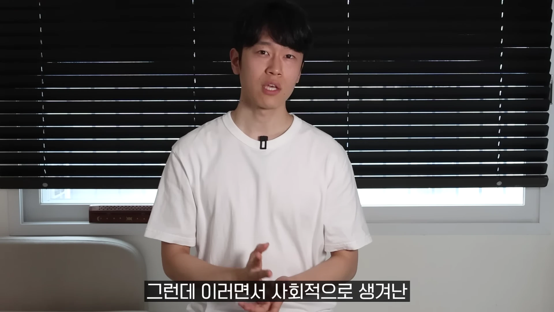 흰색 티셔츠를 입은 한 남성이 카메라를 정면으로 바라보며 이야기를 하고 있고 하단에는 자막이 떠 있습니다.