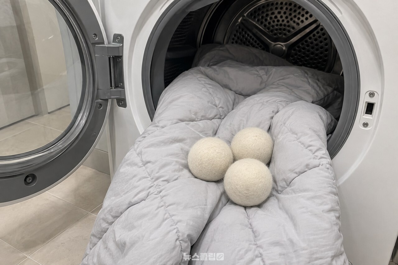건조기에 넣을 이불과 울 드라이어볼 세 개 / 기사 이해를 돕기 위한 생성형 이미지