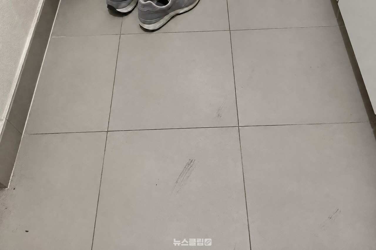 현관 타일에 남은 검은 신발 자국 / 기사 이해를 돕기 위한 생성형 이미지