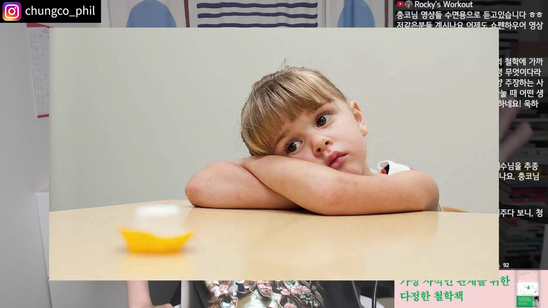 앞에 놓인 마시멜로를 턱을 괴고 쳐다보고 있는 어린아이의 모습