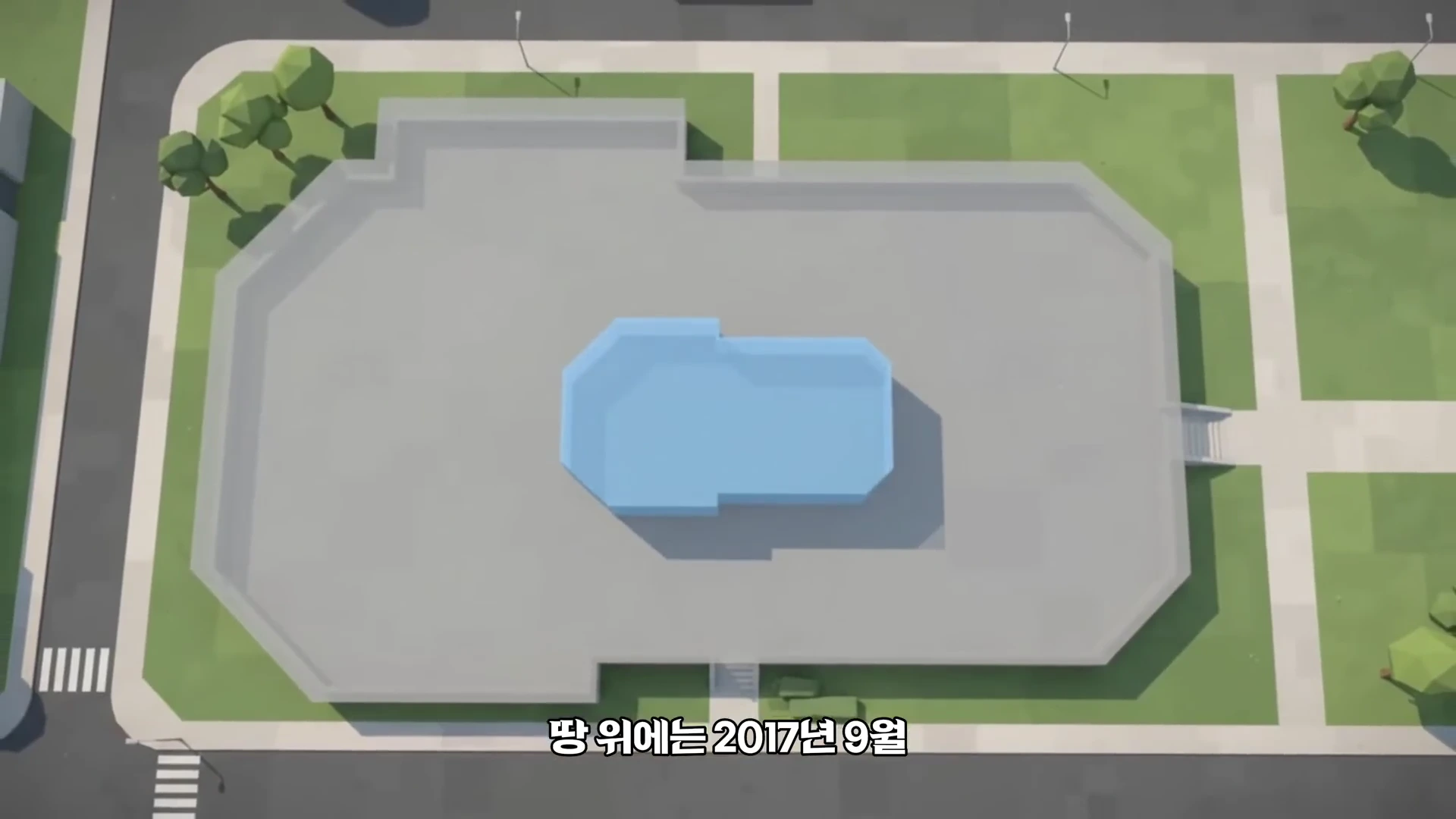 하늘에서 내려다본 지상 부지 위에 연한 파란색의 직사각형 구조물이 중앙에 배치된 모습이 담긴 그래픽 영상입니다.