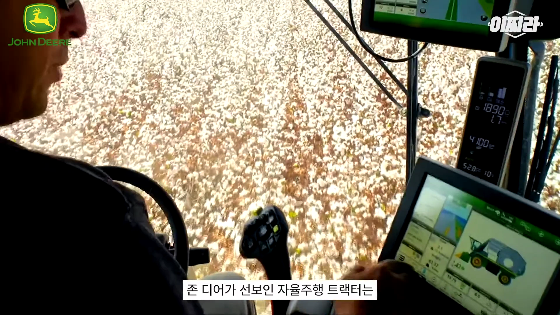 자율주행 트랙터 운전석에서 운전자가 모니터와 조작 패널을 통해 밭을 관리하는 모습이 담긴 영상 화면