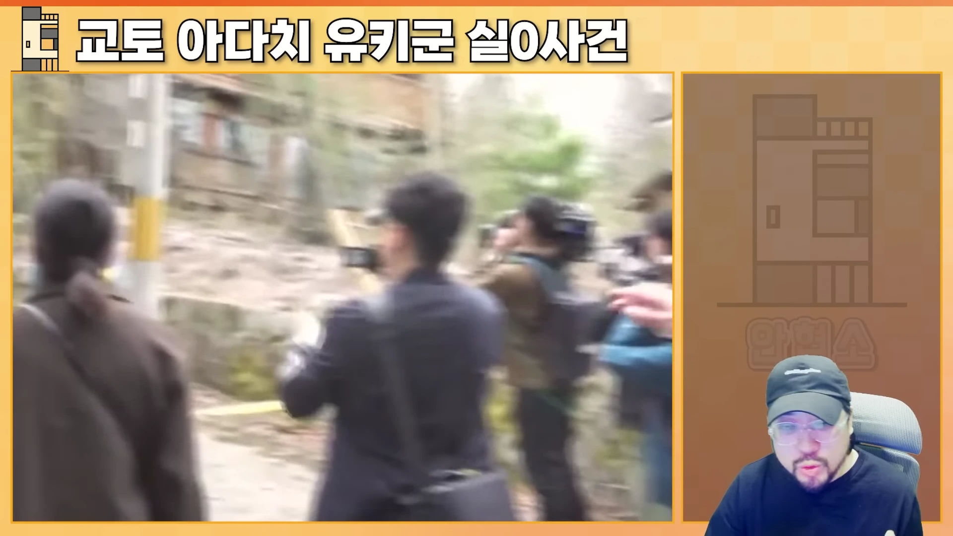 오른쪽 하단에 안경을 쓰고 모자를 쓴 남성이 앉아 있고, 왼쪽 화면에는 수많은 취재진이 모여 현장을 촬영하는 모습이 담긴 영상 프레임이 나타납니다.