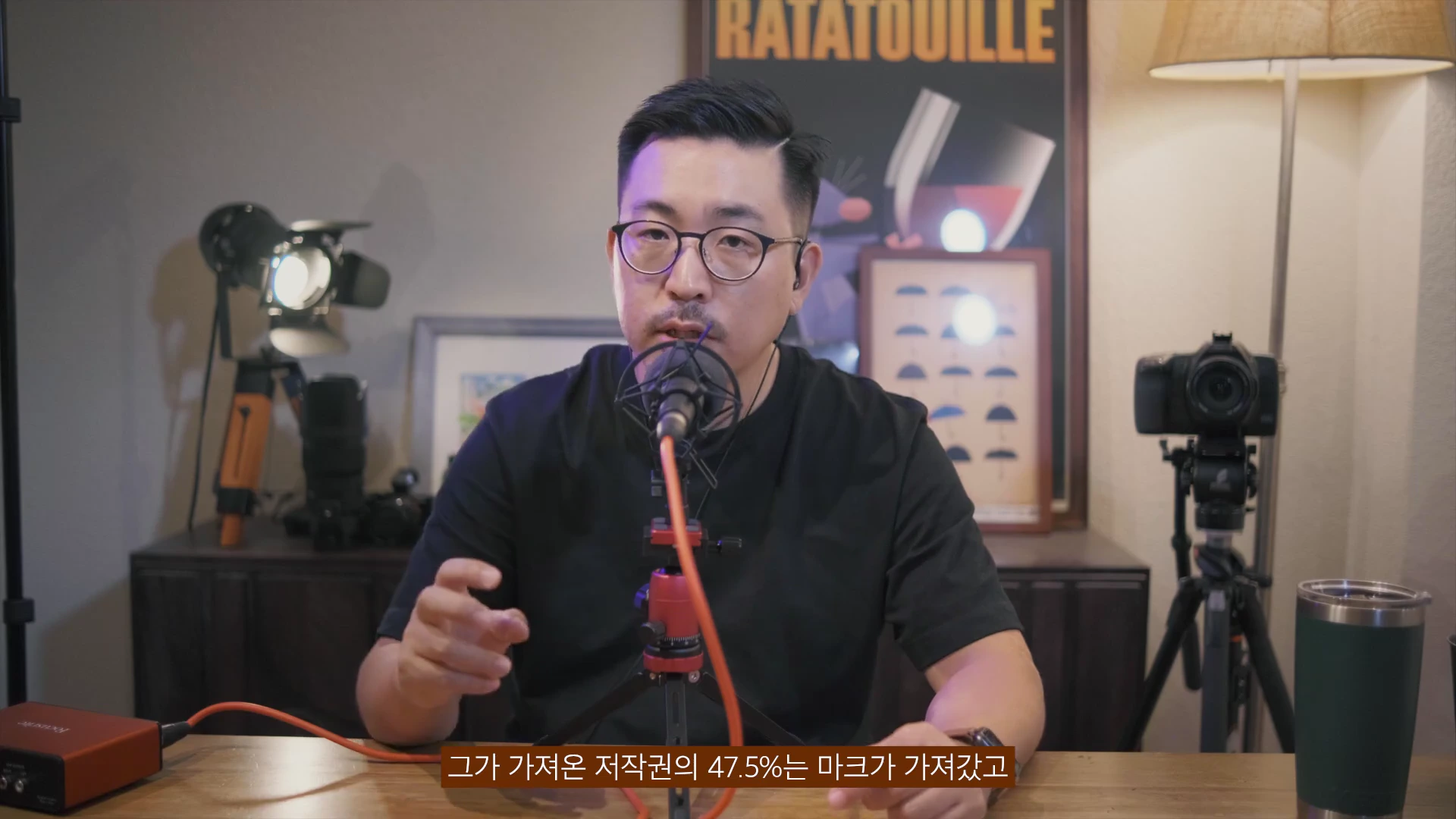 안경을 쓴 남성이 마이크를 앞에 두고 이야기를 하고 있으며, 화면 하단에는 자막이 포함되어 있습니다.