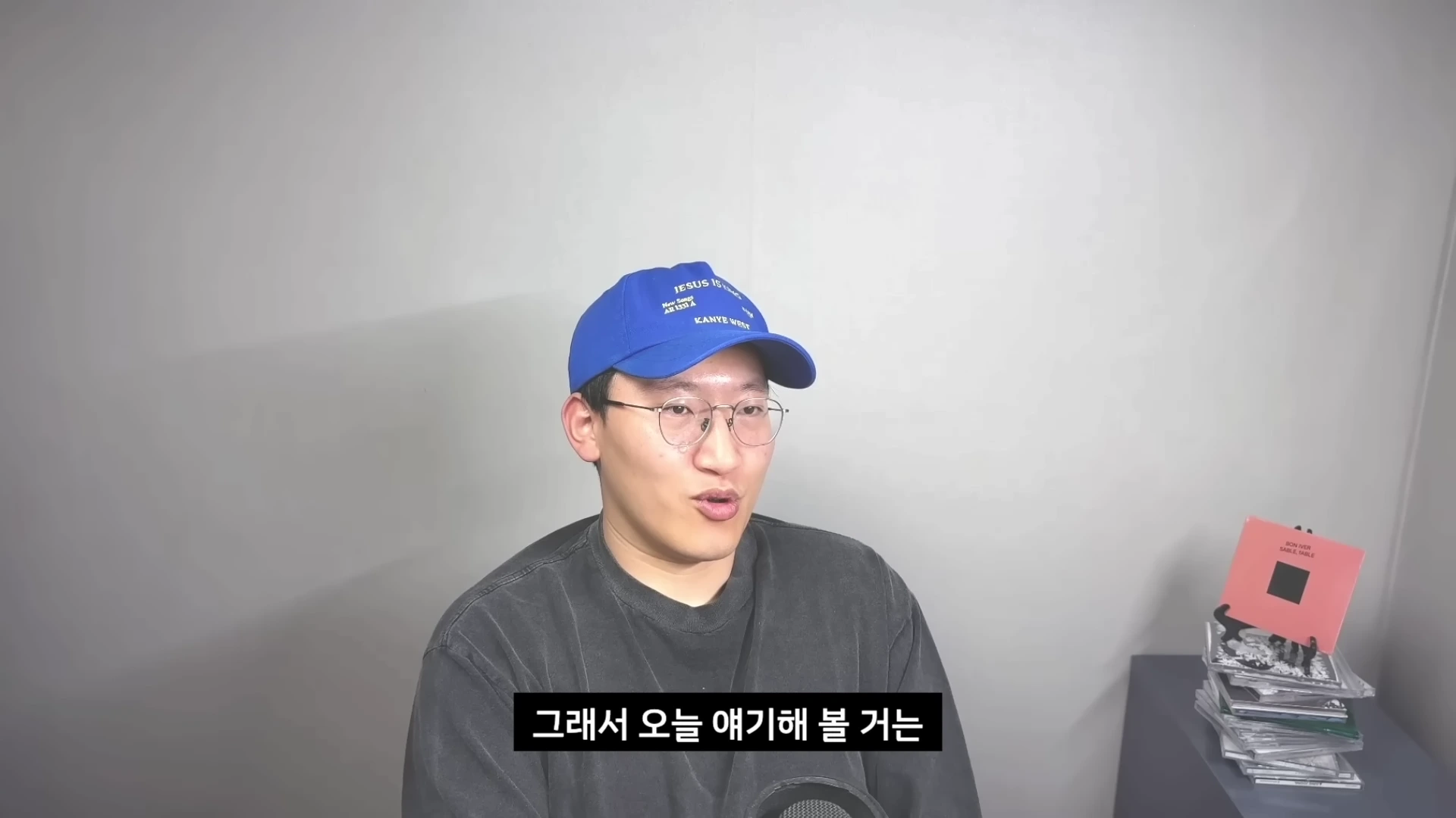 안경을 쓰고 파란색 모자를 쓴 남성이 카메라를 보며 이야기를 하고 있으며 화면 하단에는 자막이 있습니다.