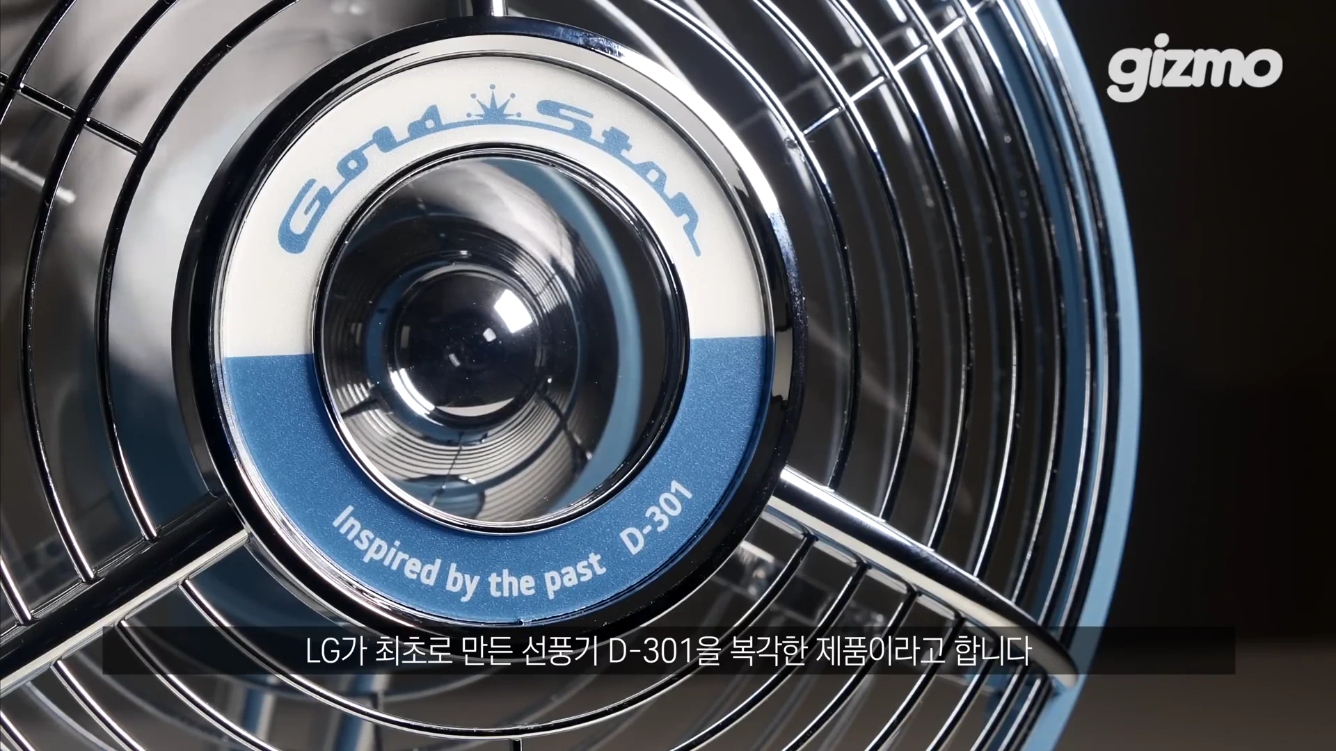 금색 왕관 로고와 'GoldStar', 'Inspired by the past D-301' 문구가 새겨진 파란색 레트로풍 선풍기 헤드 중심부의 클로즈업 샷입니다.