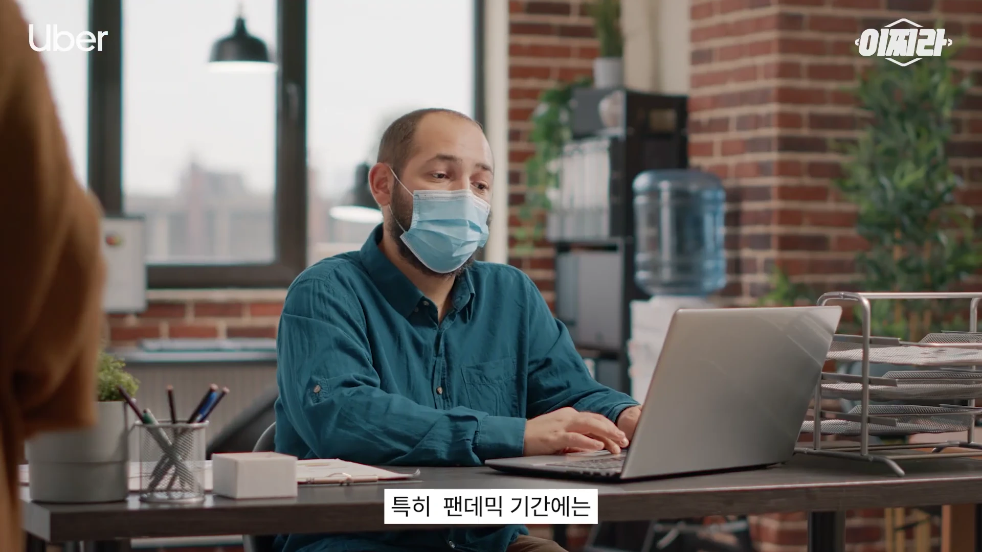 마스크를 쓴 남성이 사무실 책상에 앉아 노트북으로 업무를 보고 있는 모습이 담긴 영상 캡처 화면