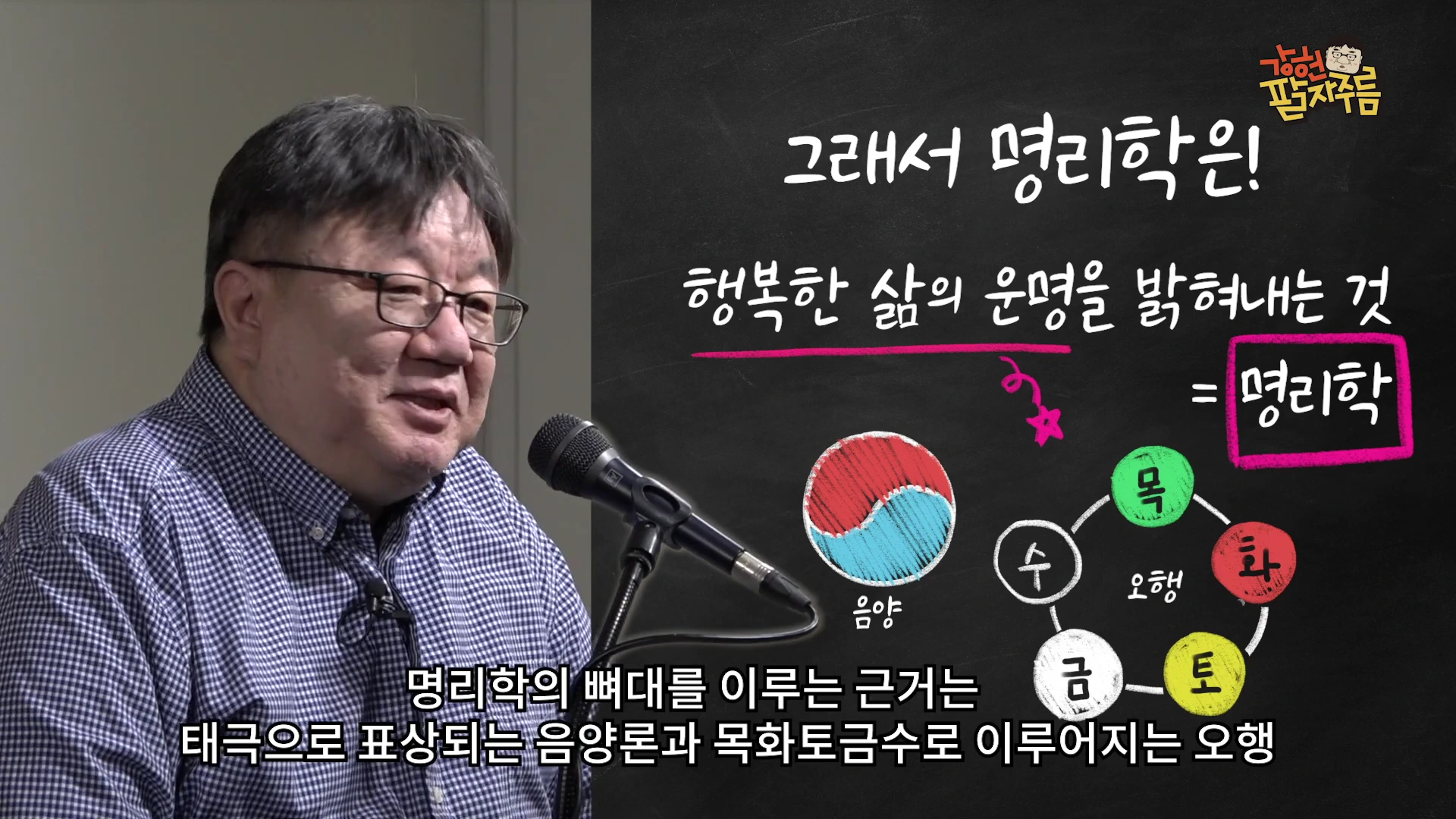 안경을 쓴 중년 남성이 마이크 앞에서 설명하고 있으며, 옆에는 음양 태극 문양과 목화토금수 오행이 그려진 검은색 칠판 배경의 화면이 합성되어 있다.