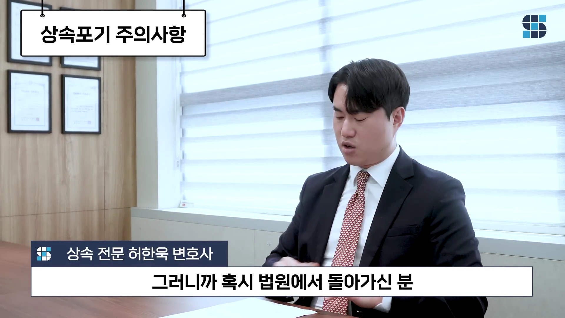 정장을 입은 변호사가 사무실에서 앉아 상속포기 주의사항을 설명하고 있는 모습의 영상 캡처 화면.