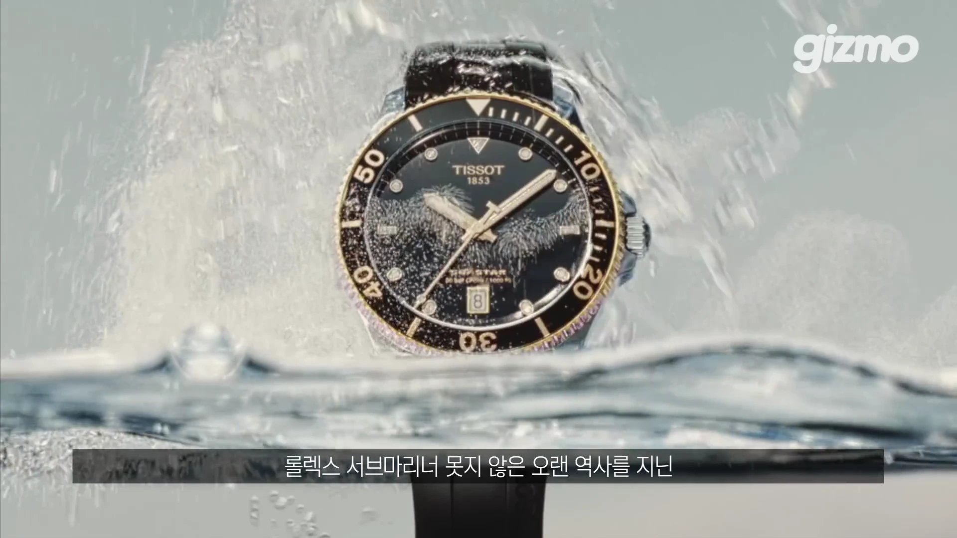 검은색 다이얼과 금색 테두리의 베젤을 가진 다이버 시계가 물속에서 튀어 올라 물방울이 맺혀 있는 모습.