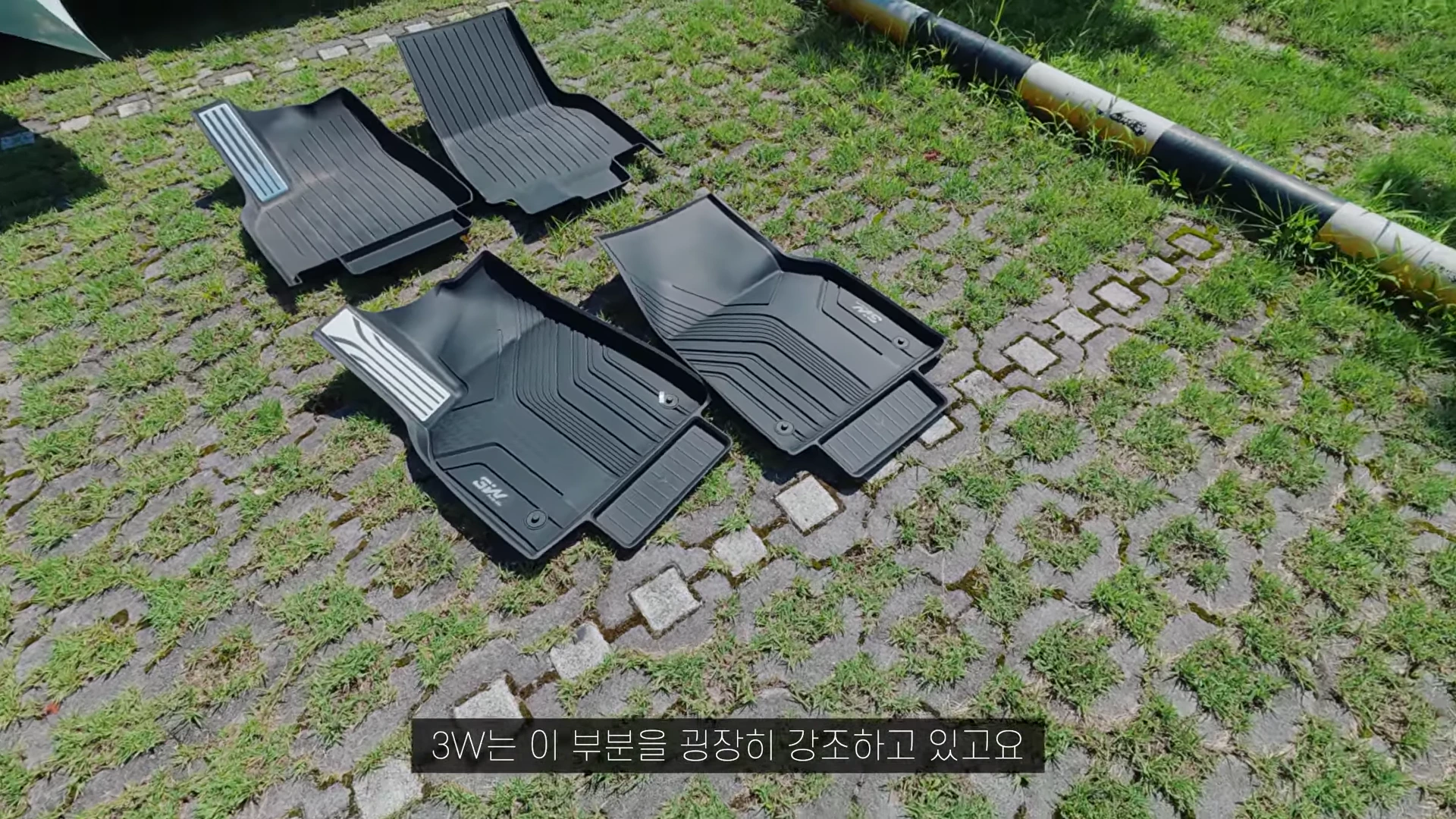잔디와 보도블록 위에 놓인 두 가지 종류의 검은색 TPE 카매트 세트가 위아래로 나란히 배치되어 있습니다.