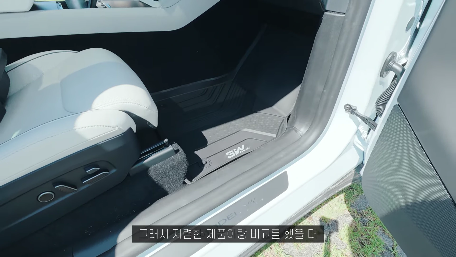 테슬라 차량 조수석 바닥에 장착된 검은색 TPE 카매트 모습. 매트 표면에는 브랜드 로고와 함께 기하학적인 트로프 패턴이 새겨져 있으며, 바닥면을 빈틈없이 감싸고 있는 형태를 보인다.