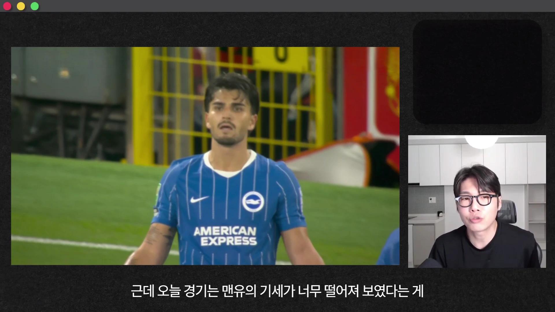 축구 경기 중 파란색 유니폼을 입은 선수가 화면 왼쪽에 보이고, 오른쪽 아래 작은 화면에는 안경을 쓴 남성이 이야기를 하고 있는 영상 캡처 화면입니다.