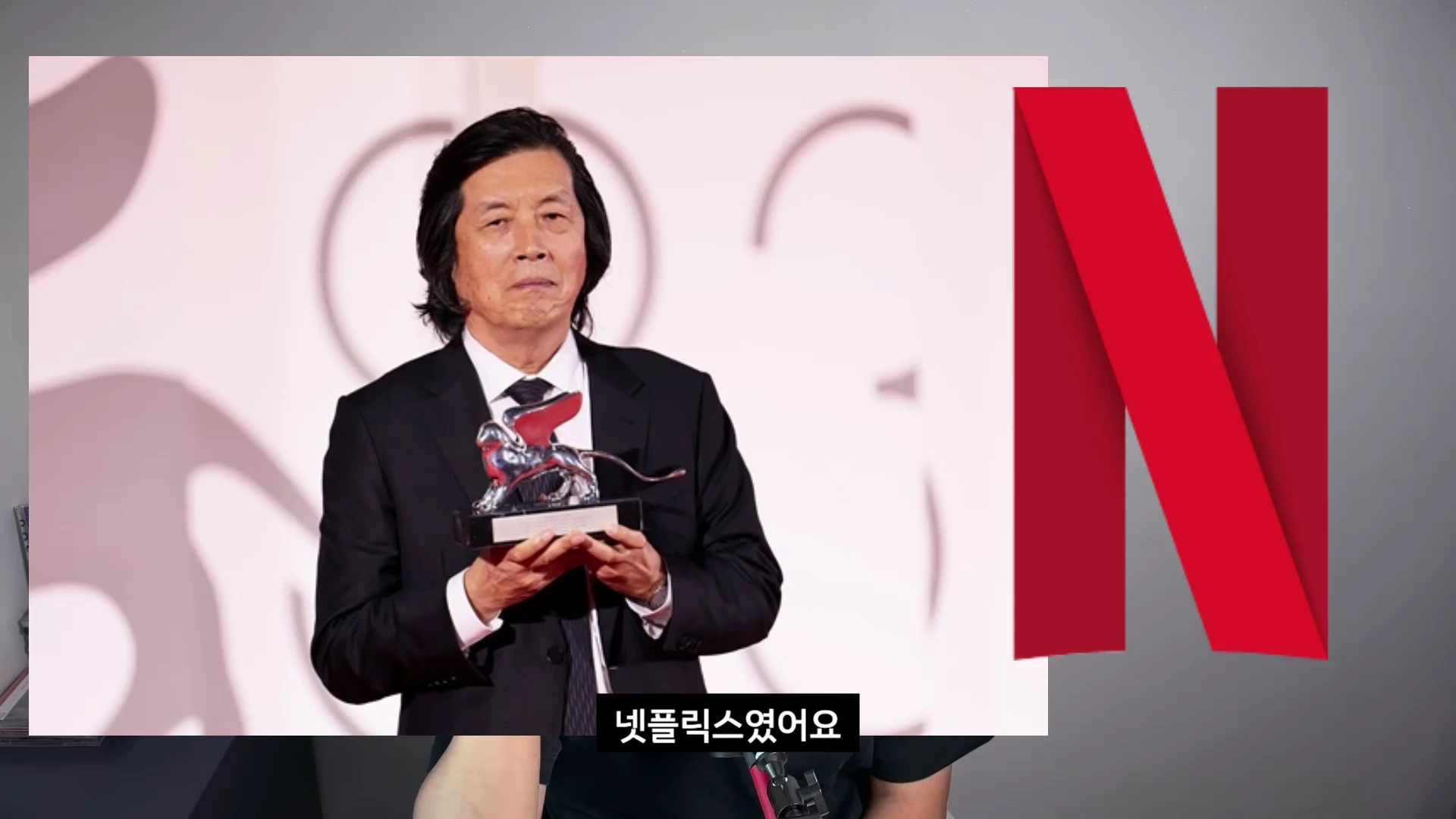베니스 영화제에서 은사자상을 들고 있는 감독의 모습과 오른쪽에 넷플릭스 로고가 배치된 화면