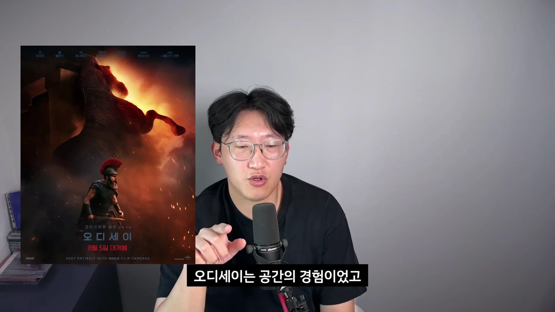 안경을 쓴 남성이 마이크 앞에서 이야기하고 있으며, 화면 왼쪽에는 '오디세이'라는 제목의 영화 포스터가 함께 떠 있습니다.