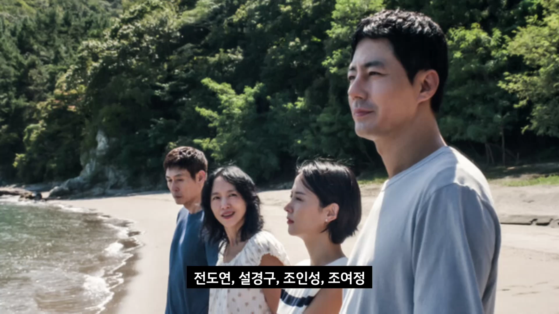 해변가에 나란히 서서 먼 곳을 바라보는 네 명의 배우들의 모습이 담긴 영화의 한 장면입니다.