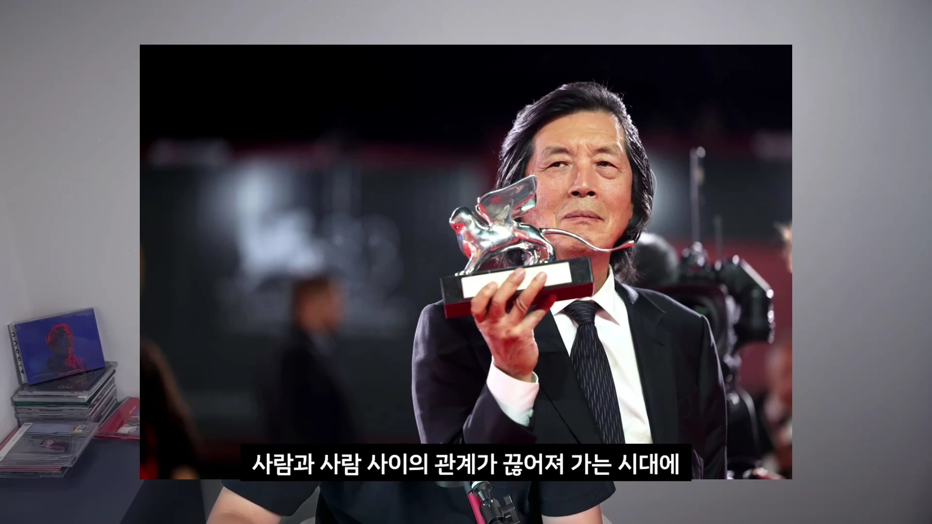 정장을 입은 중년 남성이 은색 사자 트로피를 들고 있는 모습이 담긴 영상 캡처 화면이며, 하단에는 한국어 자막이 표시되어 있습니다.