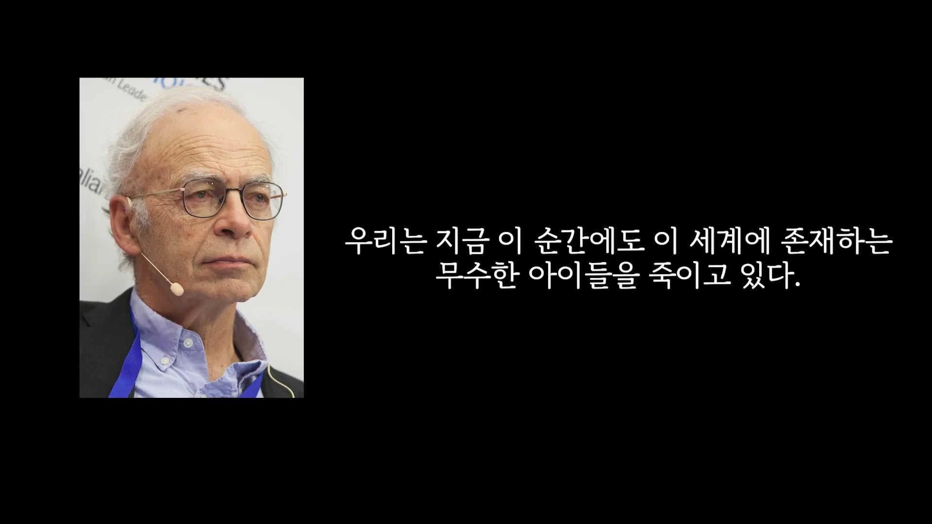 흰 머리에 안경을 쓴 노신사가 헤드셋 마이크를 착용한 채 정면을 응시하고 있는 모습 옆으로 '우리는 지금 이 순간에도 이 세계에 존재하는 무수한 아이들을 죽이고 있다'라는 자막이 배치되어 있습니다.