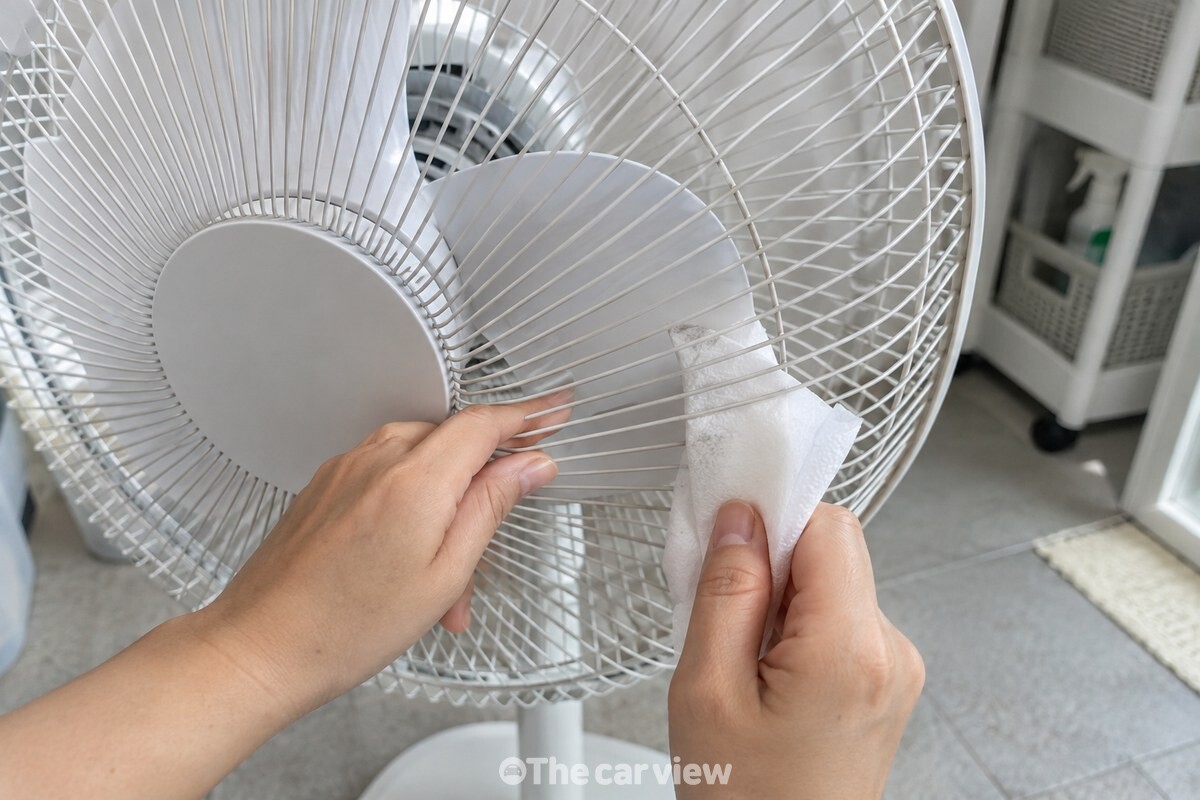 키친타월을 안전망 틈으로 넣어 날개를 닦는 모습 / 기사 이해를 돕기 위한 생성형 이미지