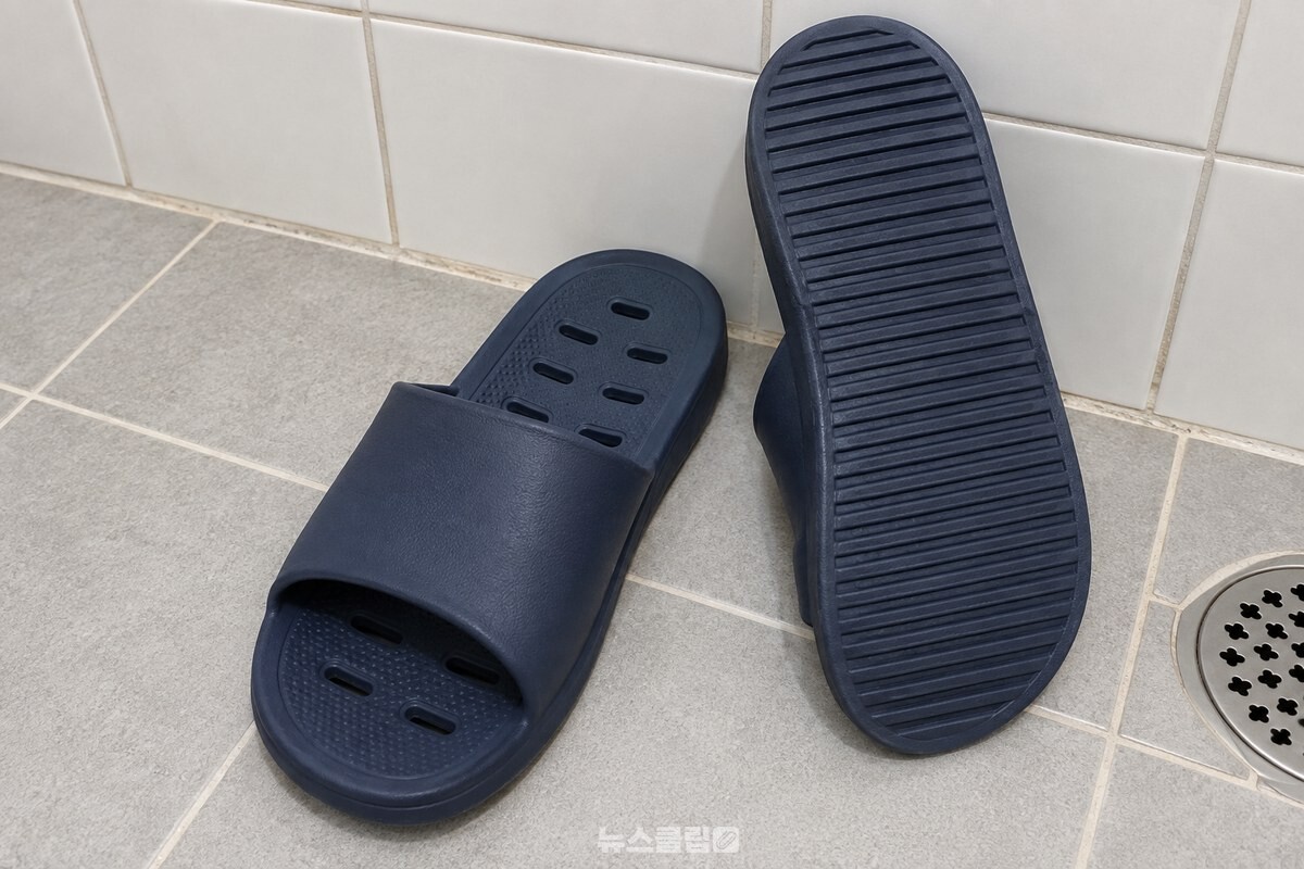 욕실 바닥에 나란히 놓인 고무 슬리퍼 한 켤레와 그 옆에 세워 둔 한 짝의 바닥 홈. / 기사 이해를 돕기 위한 생성형 이미지