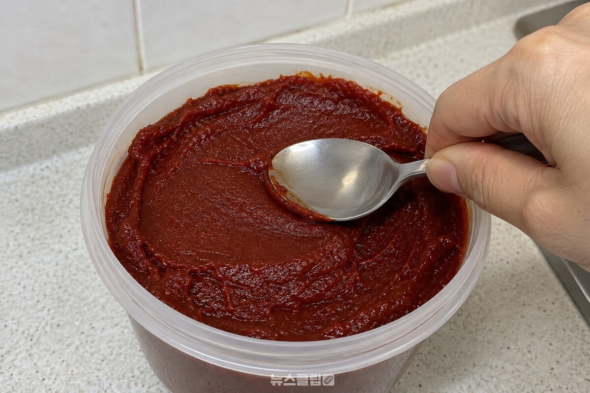 마른 숟가락 뒷면으로 고추장 표면을 평평하게 고르는 모습 / 기사 이해를 돕기 위한 생성형 이미지