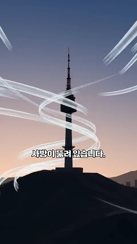 노을이 지는 남산 위에 우뚝 솟은 타워 주변으로 하얀 바람의 흐름이 그래픽으로 표현되어 있으며 화면 중앙에 자막이 적힌 영상 프레임