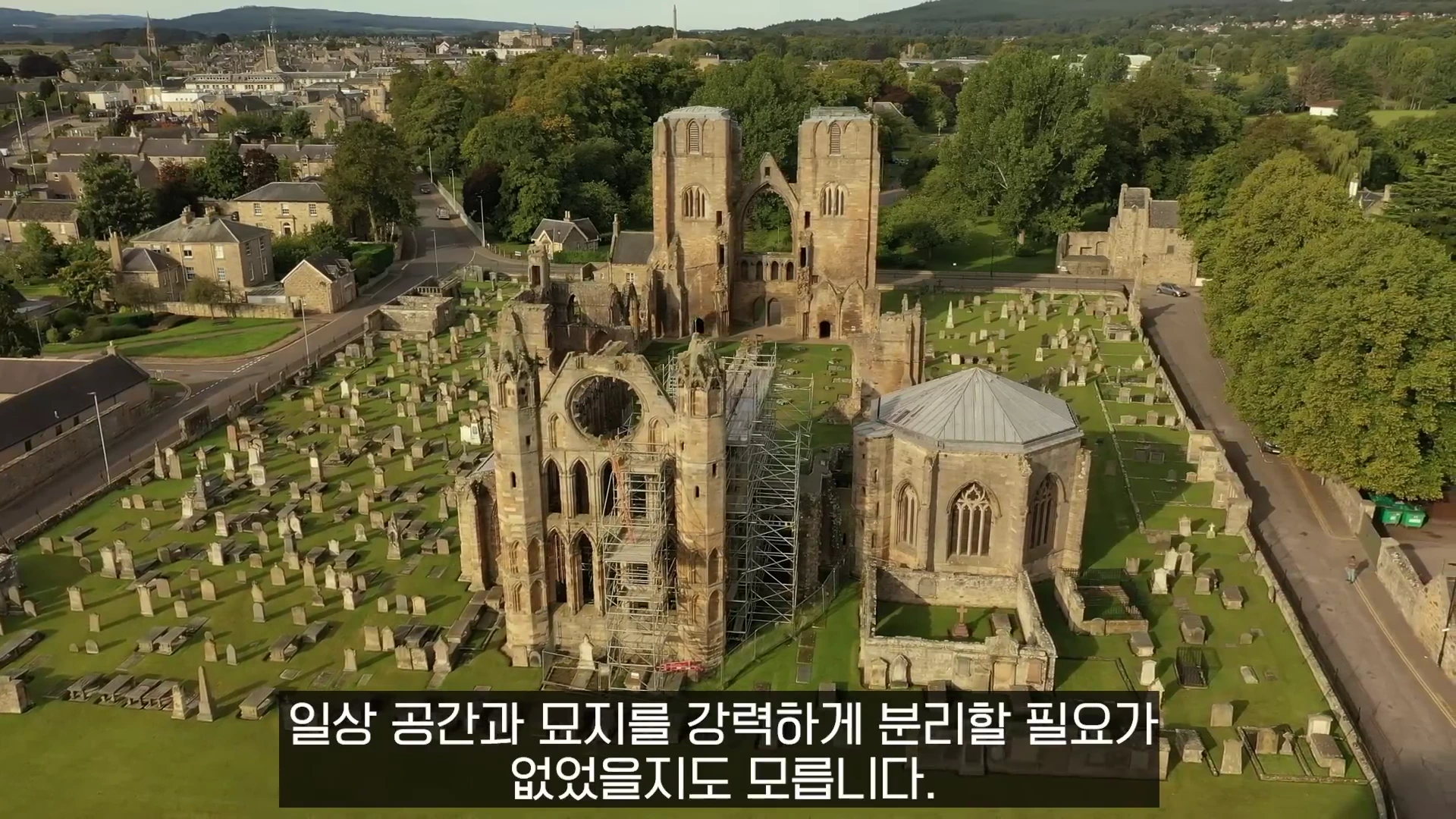 공중에서 내려다본 오래된 석조 성당 유적과 그 주변을 둘러싼 넓은 묘지의 모습