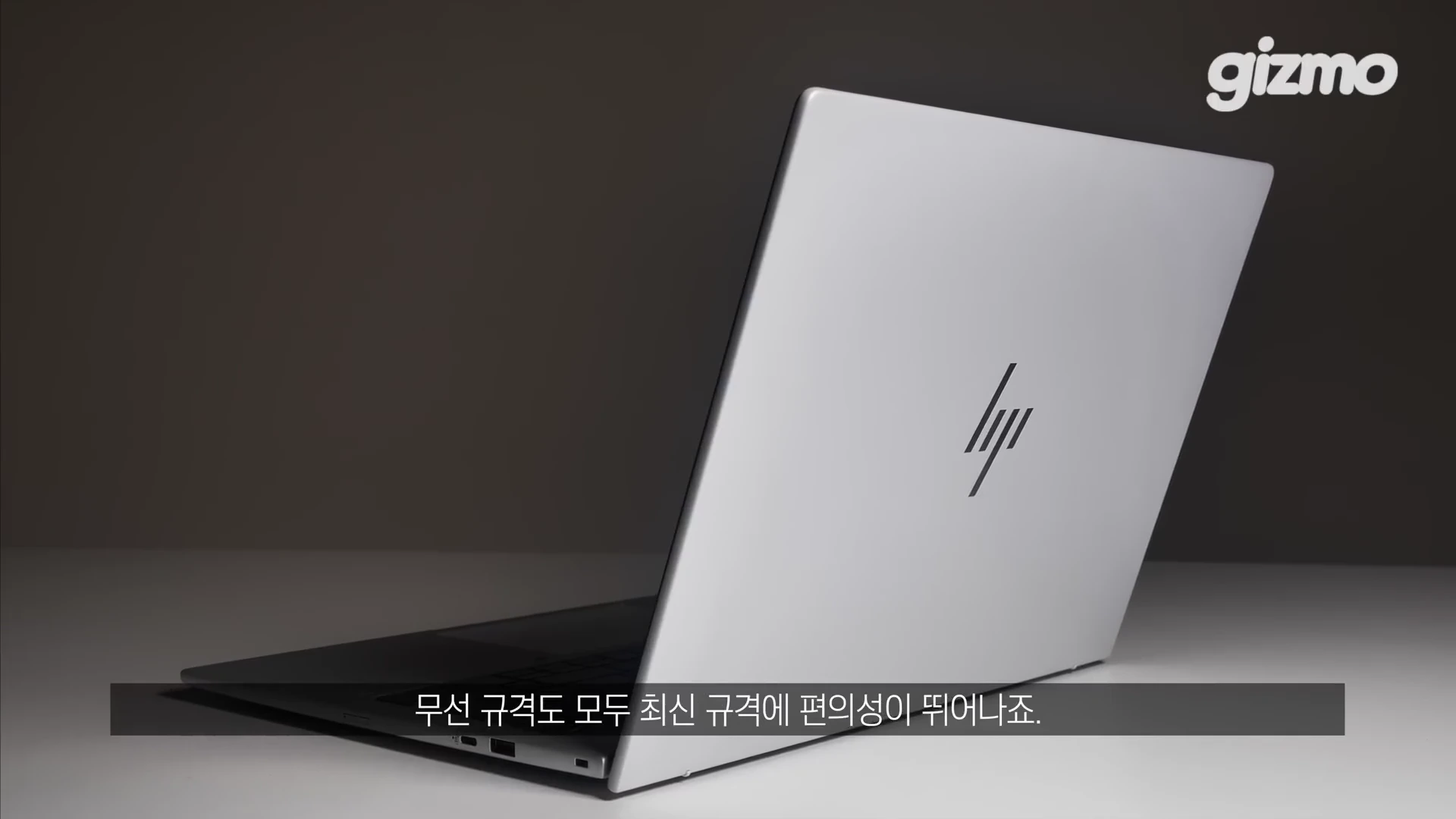 은색 HP 로고가 중앙에 위치한 엘리트북 노트북의 뒷면과 측면이 보이는 클로즈업 샷이며, 화면 하단에는 자막이 있습니다.