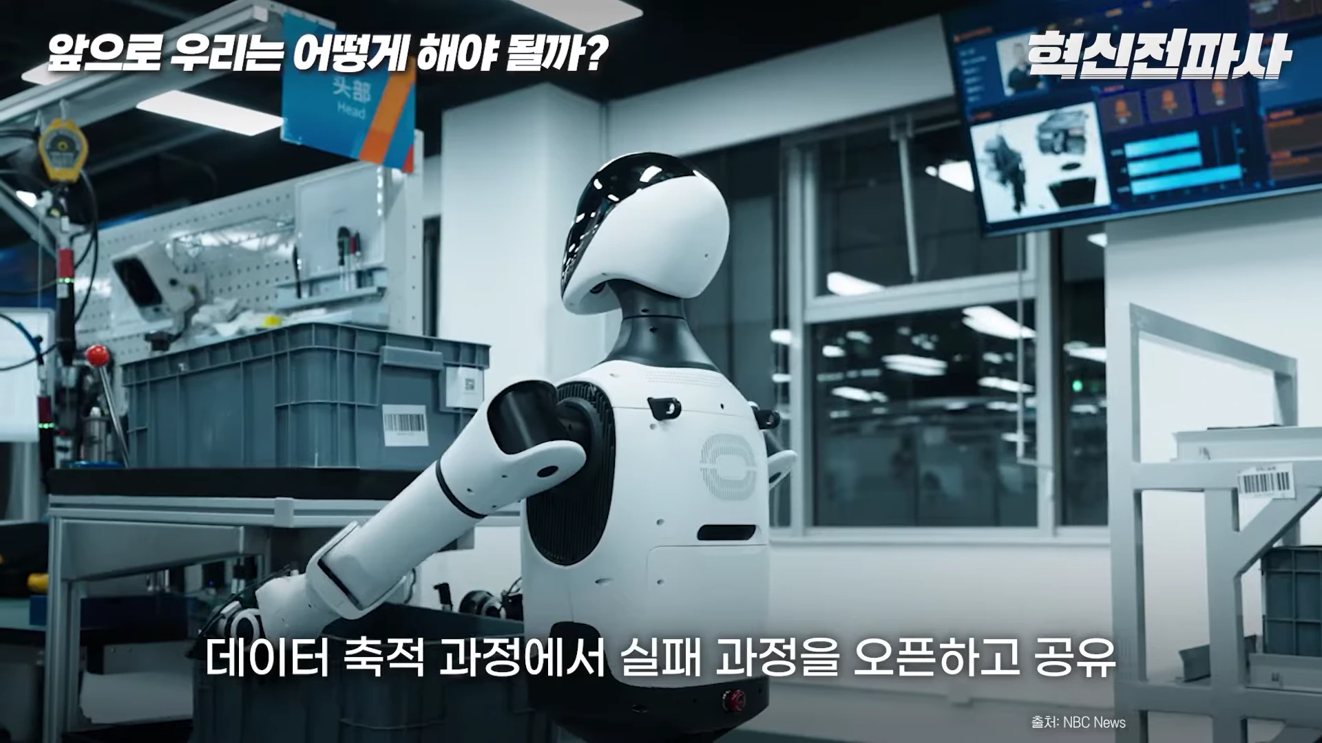 연구실 작업대에 서 있는 흰색 휴머노이드 로봇의 뒷모습.