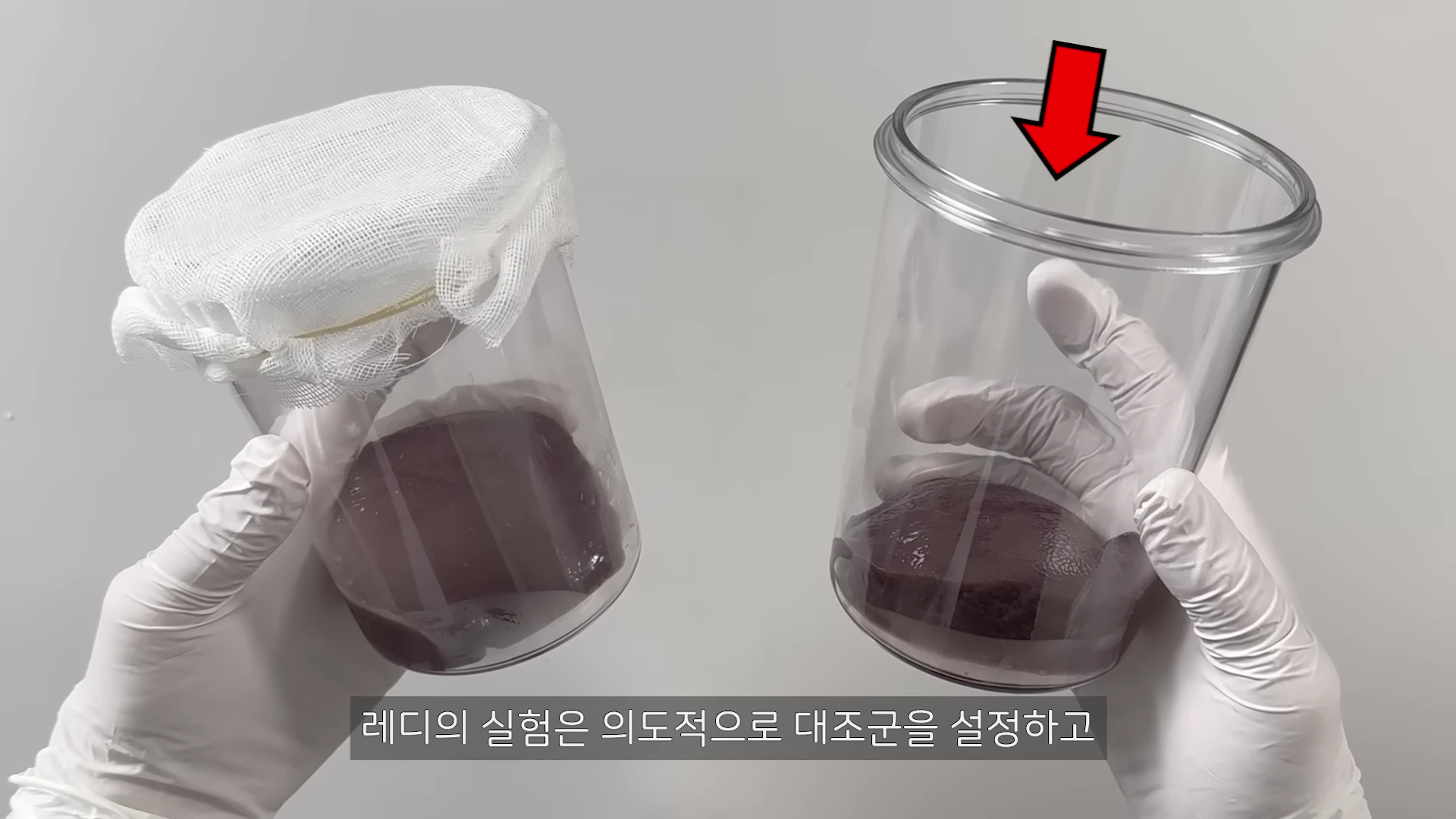흰 장갑을 낀 두 손이 각각 거즈로 덮인 유리병과 뚫린 유리병을 들고 있으며, 뚫린 병 위쪽에는 빨간색 아래 방향 화살표가 표시되어 있다.