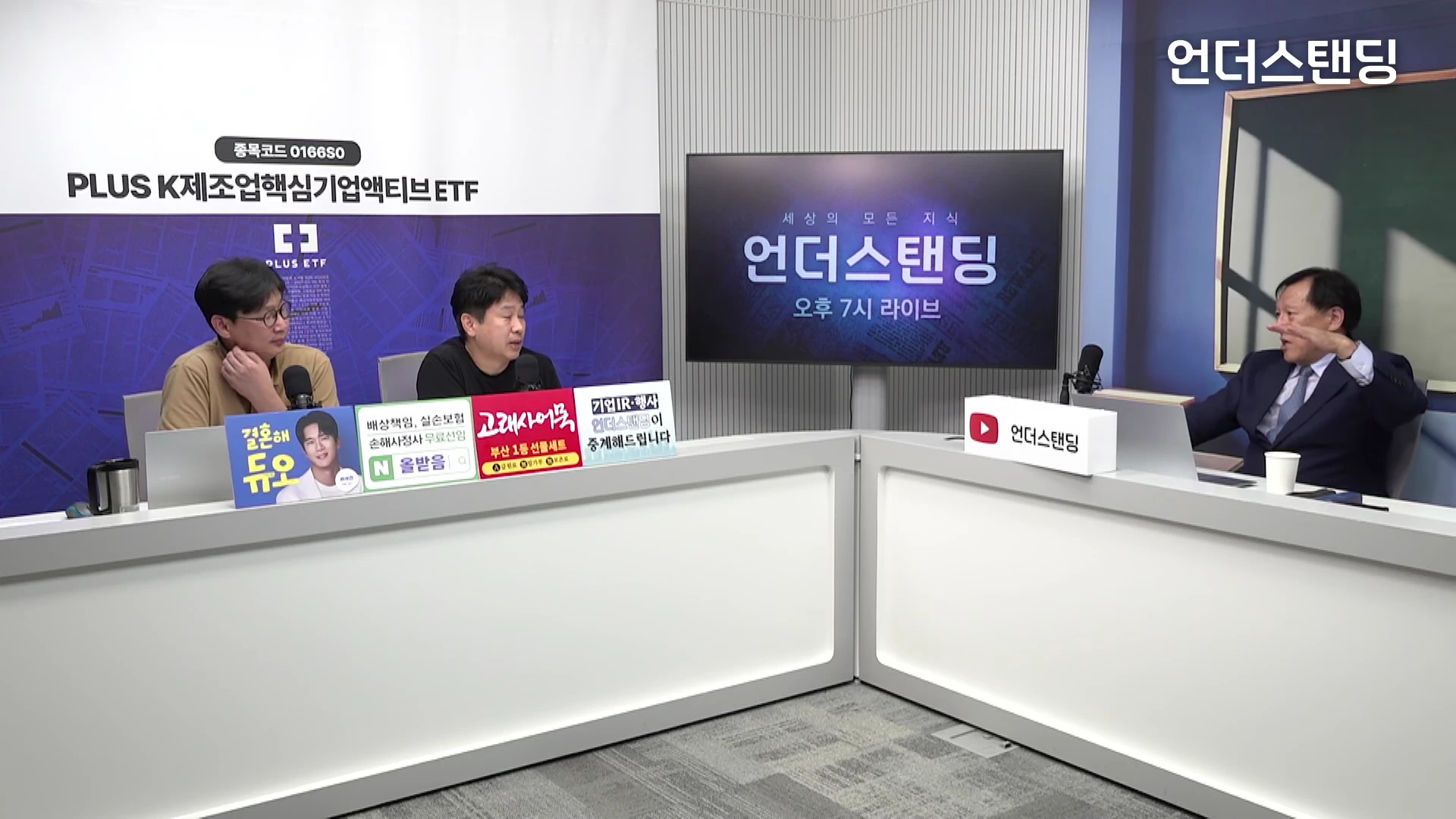 스튜디오 조명 아래 세 명의 출연자가 'ㄴ'자 형태의 흰색 테이블을 사이에 두고 앉아 대화를 나누고 있다. 뒤편에는 '언더스탠딩' 로고가 담긴 대형 디스플레이와 홍보 문구가 보인다.