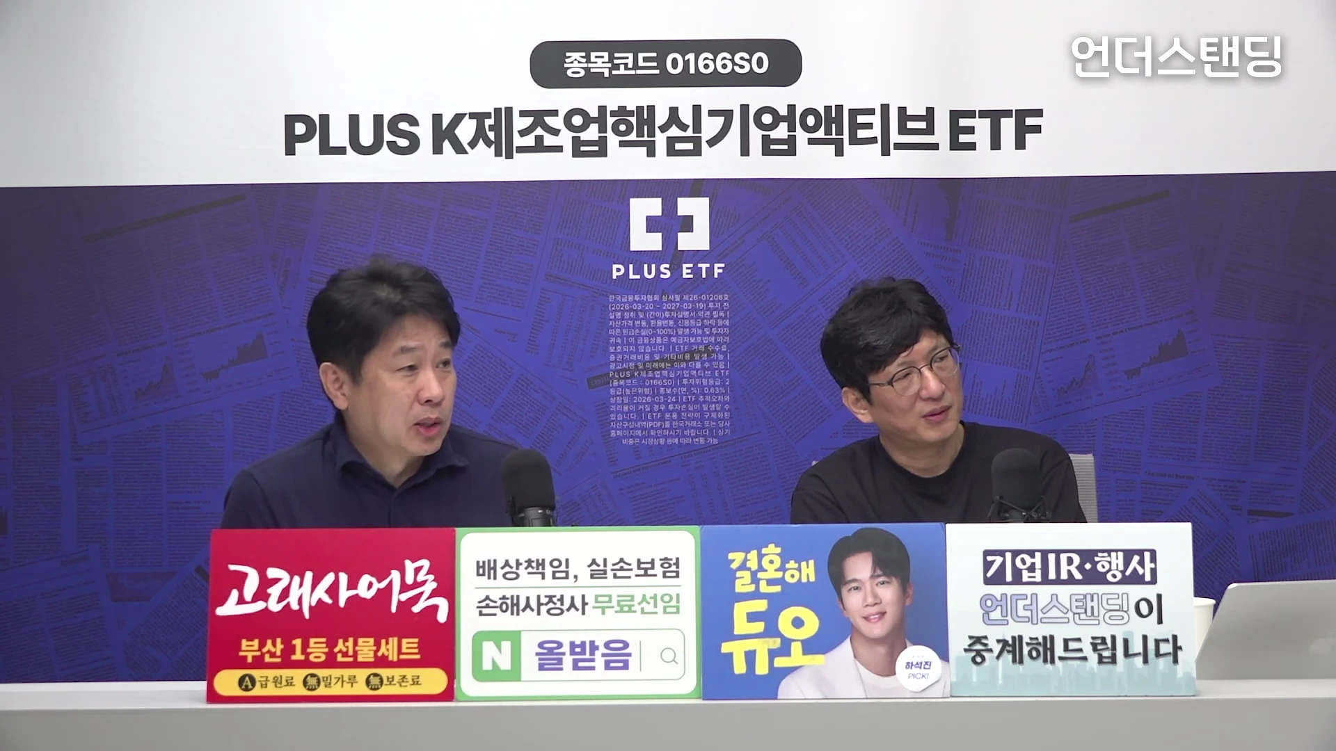 두 명의 남성이 스튜디오 테이블에 앉아 마이크를 앞에 두고 대화를 나누고 있는 모습입니다. 화면 중앙 상단에는 'PLUS K제조업핵심기업액티브 ETF'와 종목 코드가 적힌 자막이 있으며, 테이블 앞에는 여러 광고 문구가 붙어 있습니다.