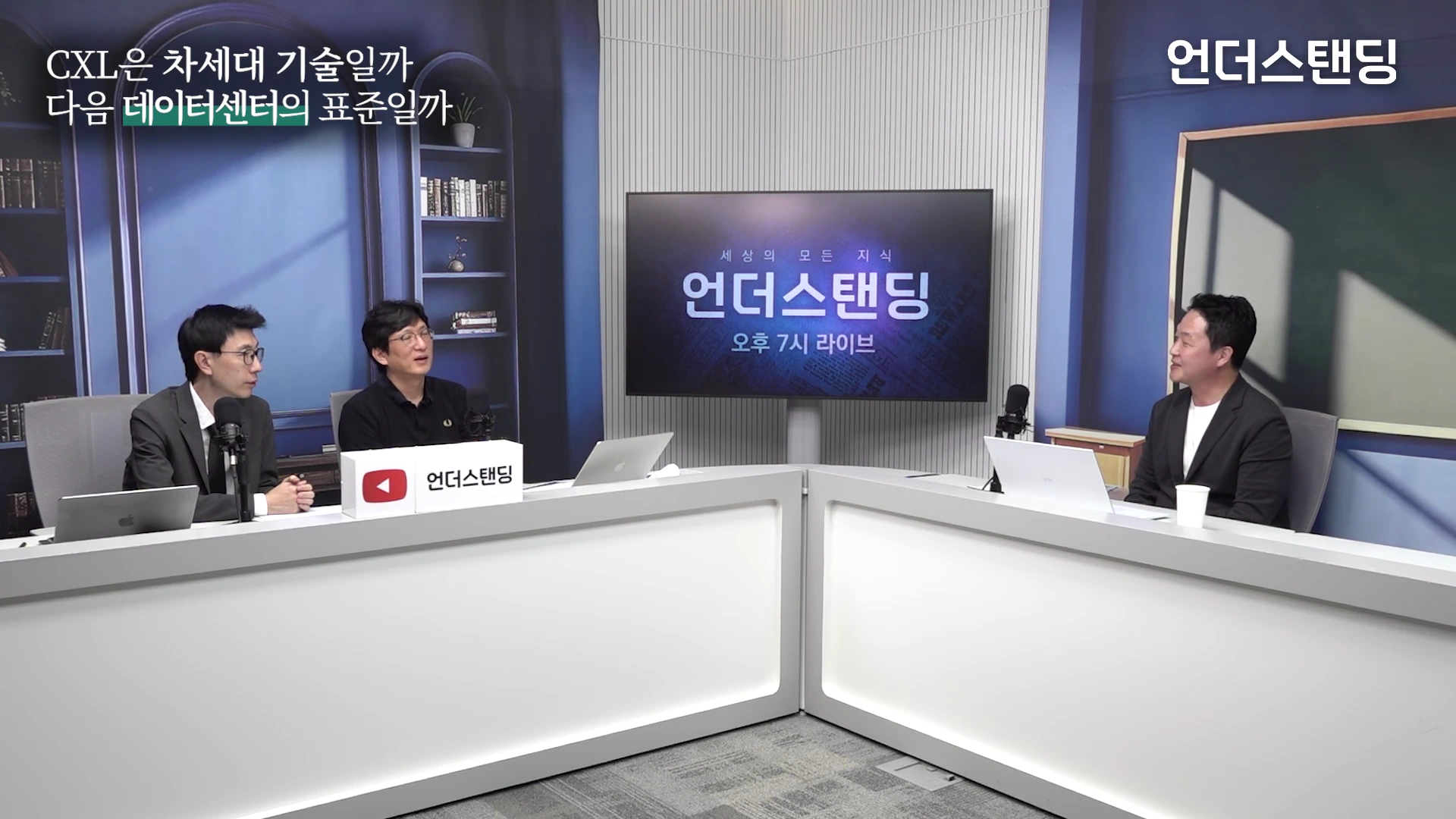 스튜디오에 모인 세 명의 남성이 책상에 앉아 대담을 나누고 있는 모습.