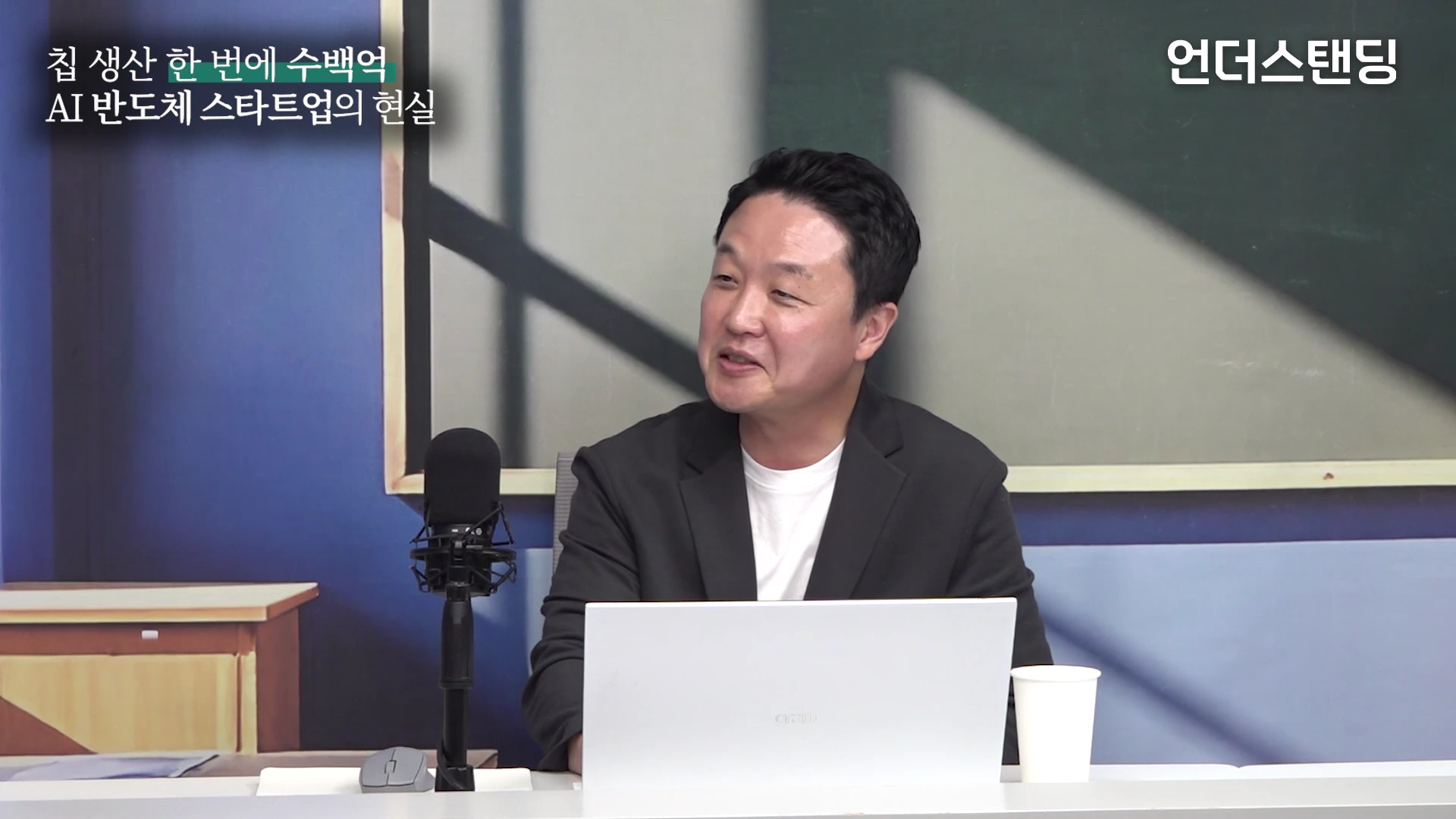 실내 스튜디오에 앉아 있는 남성이 마이크 앞에서 대화를 나누고 있으며, 화면 왼쪽 상단에는 '칩 생산 한 번에 수백억, AI 반도체 스타트업의 현실'이라는 자막이 표시되어 있습니다.
