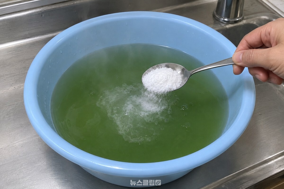 대야에 덜어 둔 데친 물에 밥숟가락으로 베이킹소다 두 스푼 반을 넣고 젓는 모습이다. / 기사 이해를 돕기 위한 생성형 이미지