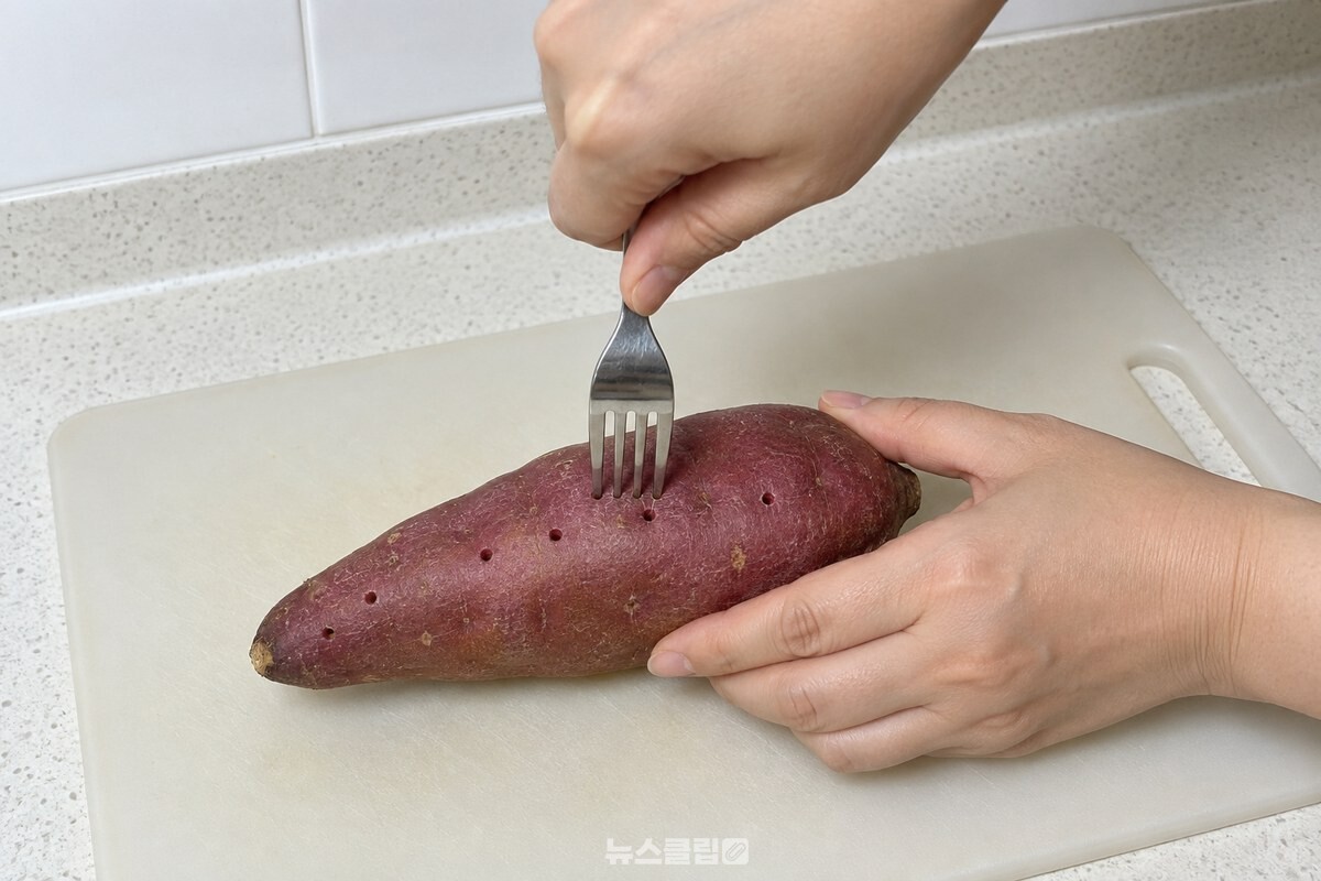 씻은 고구마의 굵은 쪽과 가는 쪽을 포크로 찔러 구멍을 내고 있다. / 기사 이해를 돕기 위한 생성형 이미지