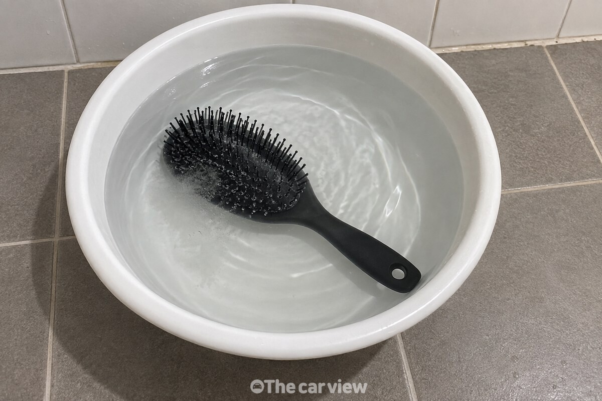 흰 대야에 미지근한 물을 부어 빗이 잠긴 상태로, 빗살 사이에서 작은 기포가 올라오고 있다. / 기사 이해를 돕기 위한 생성형 이미지