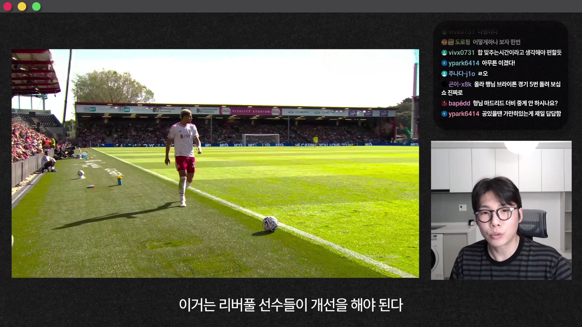 축구 경기 장면이 나오는 영상과 이를 분석하는 남성이 있는 유튜브 화면. 왼쪽에는 경기장 터치라인 근처에 선 선수가 보이고, 오른쪽에는 안경을 쓴 남성이 이야기하는 모습과 실시간 채팅창이 있음.