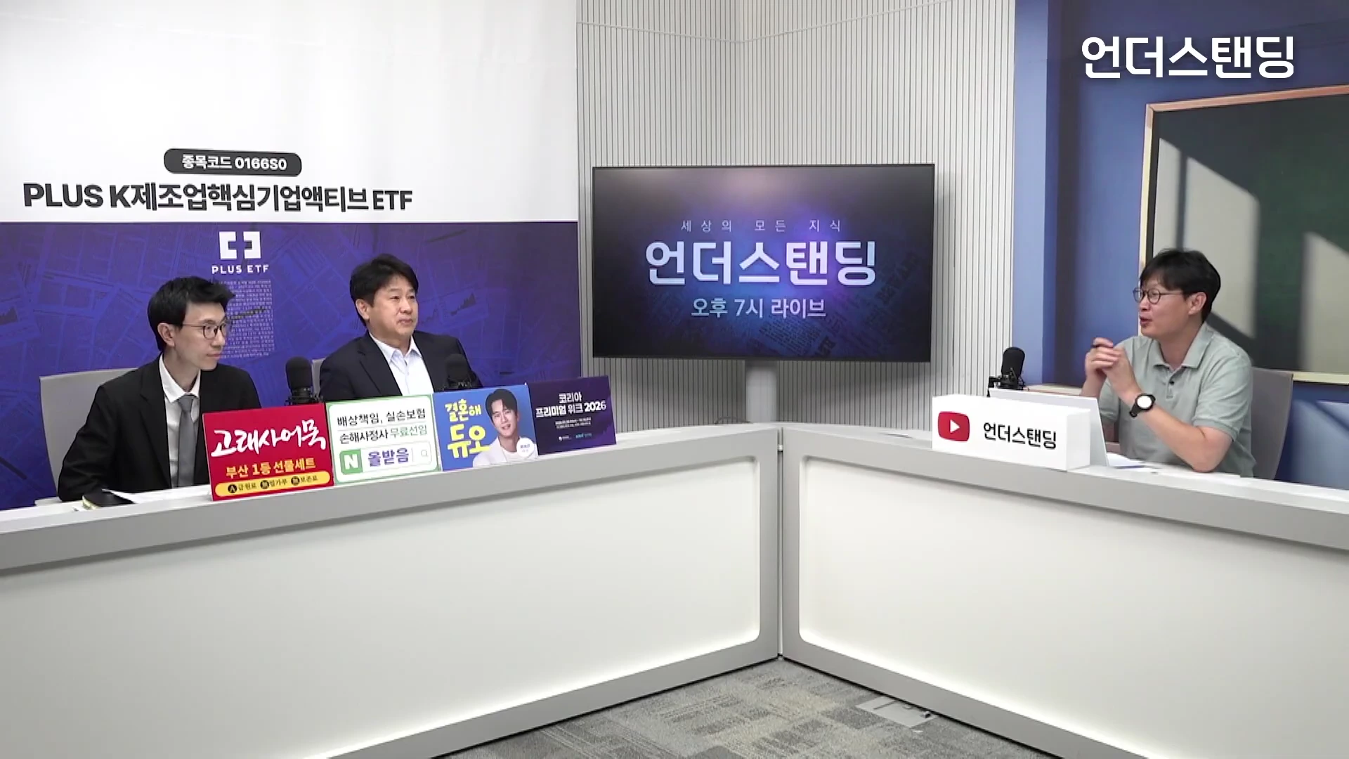 세 명의 남성이 스튜디오 책상에 앉아 대담을 나누고 있는 모습으로, 벽면에는 프로그램 로고가 띄워진 대형 화면이 배치되어 있습니다.