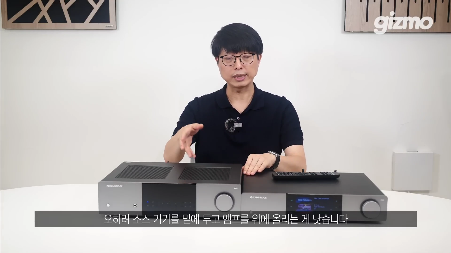 안경을 쓴 남성이 테이블 위에 놓인 캠브리지 오디오의 인티앰프와 네트워크 스트리머 두 대를 앞에 두고 설명하고 있다.