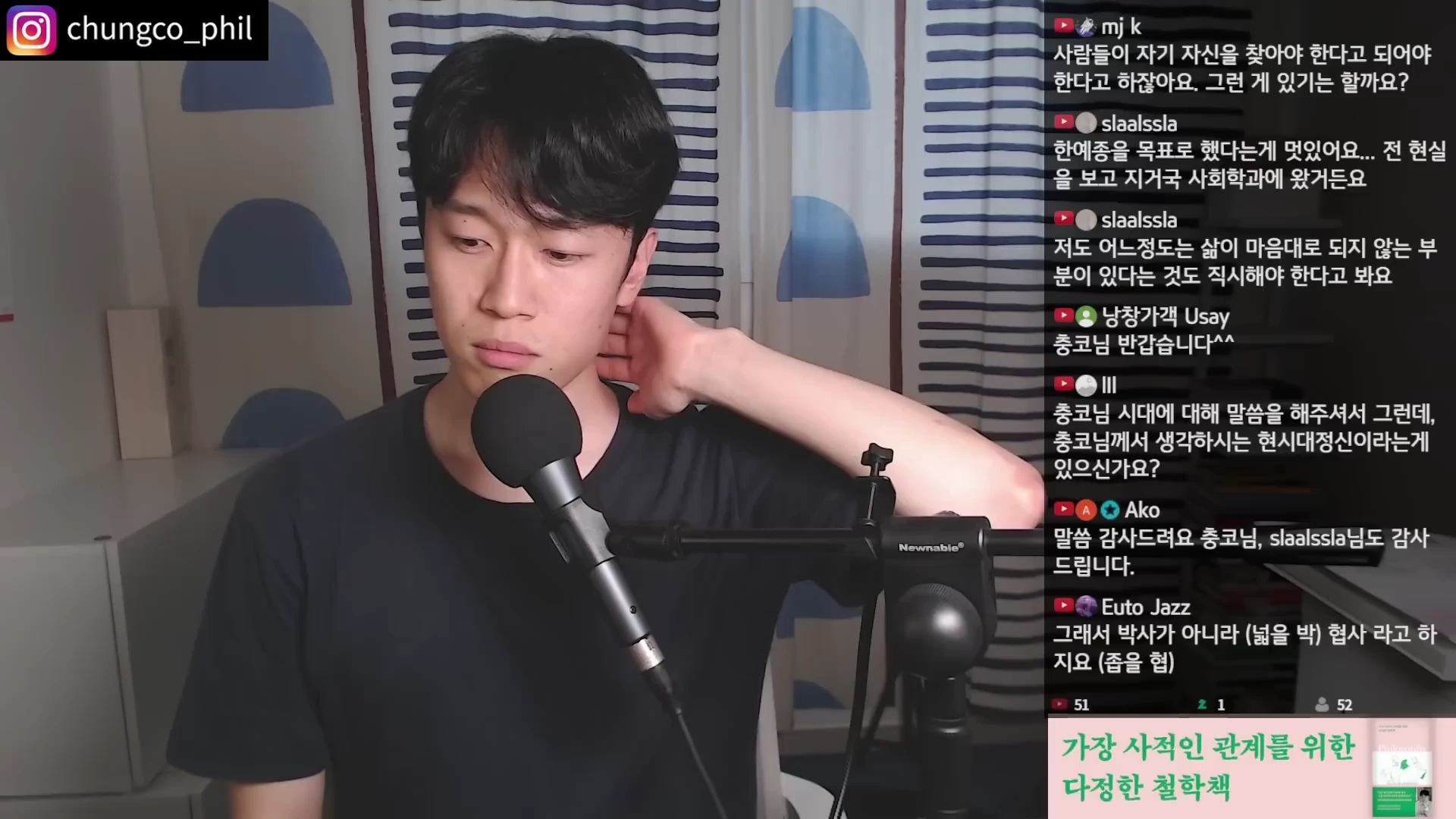 검은색 티셔츠를 입은 젊은 남성이 마이크 앞에 앉아 고민하는 듯한 표정으로 뒷목을 잡고 있으며, 화면 오른쪽에는 실시간 채팅창이 떠 있는 라이브 방송 화면