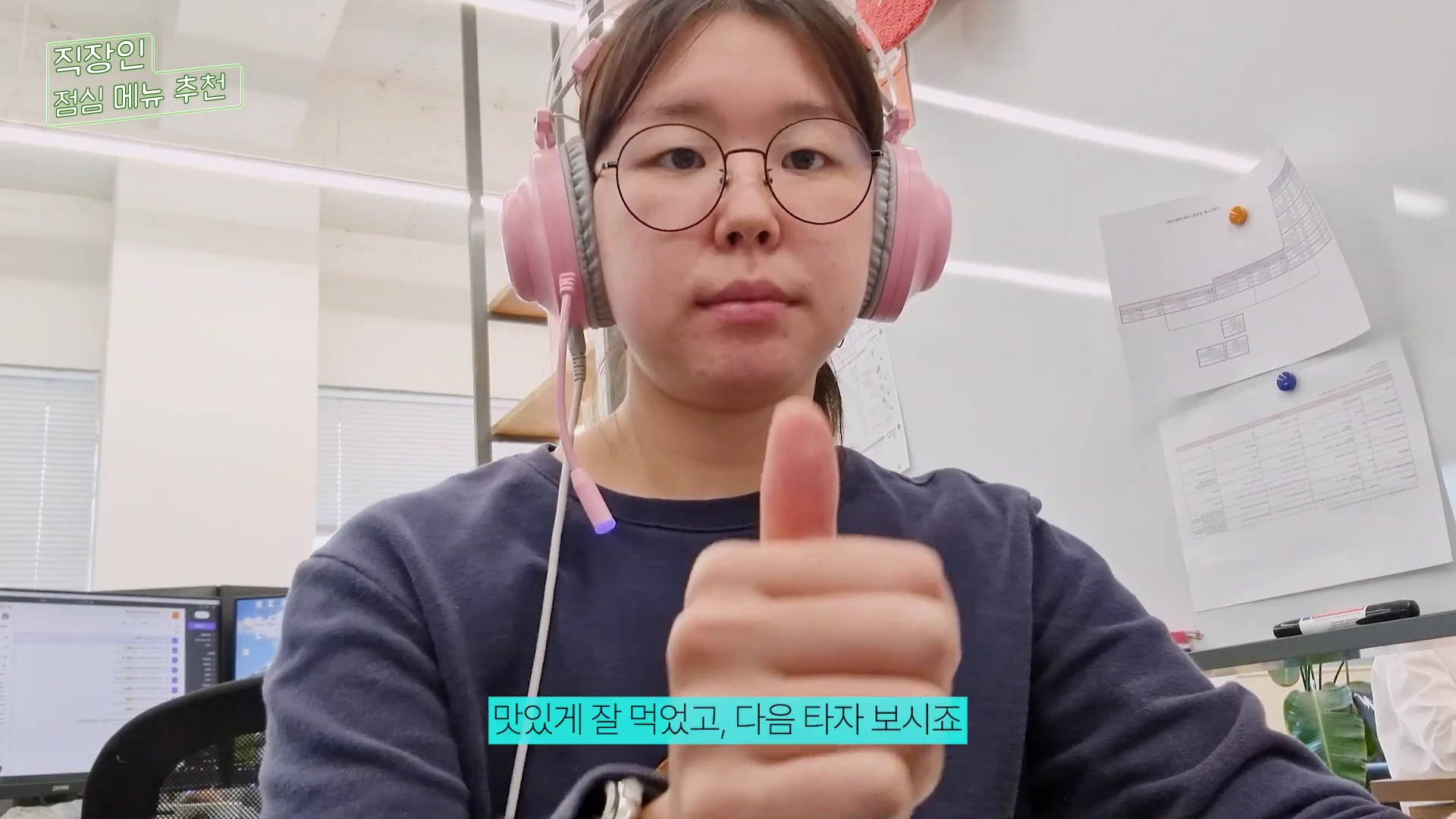 헤드셋을 착용한 여성이 카메라를 향해 엄지손가락을 들어 올리고 있는 모습