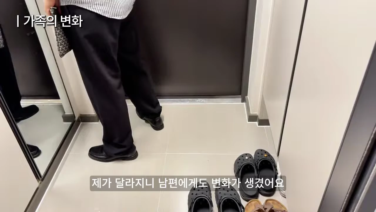 실내 현관에서 검은색 바지를 입은 한 사람이 서 있고 바닥에는 여러 켤레의 신발이 가지런히 놓여 있는 모습.